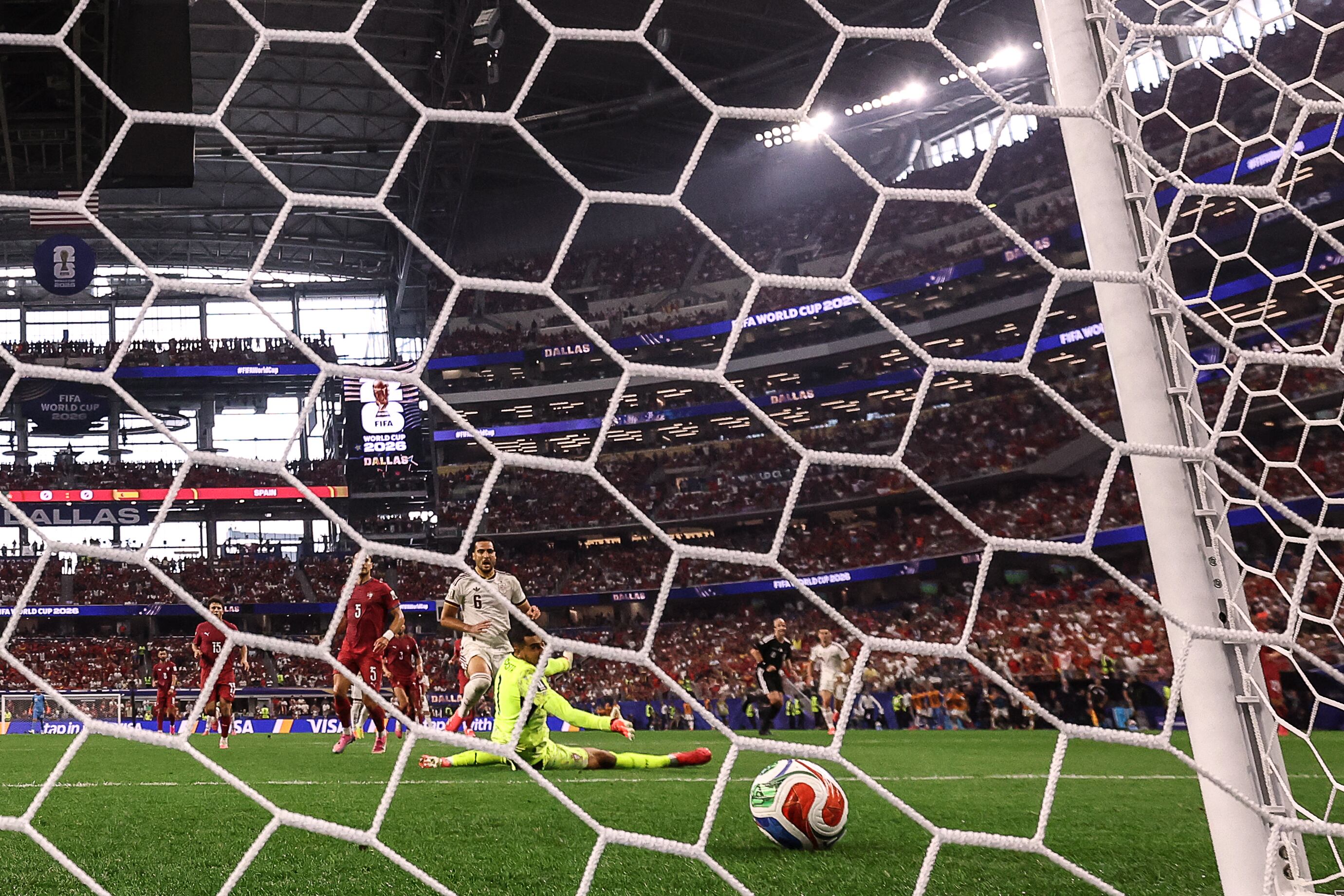 Spain's midfielder #06 Mikel Merino scores his team's first goal past Portugal's goalkeeper #01 Diogo Costa during the 2026 World Cup round of 16 football match between Portugal and Spain at the Dallas Stadium in Arlington on July 6, 2026. (Photo by Thomas COEX / AFP)