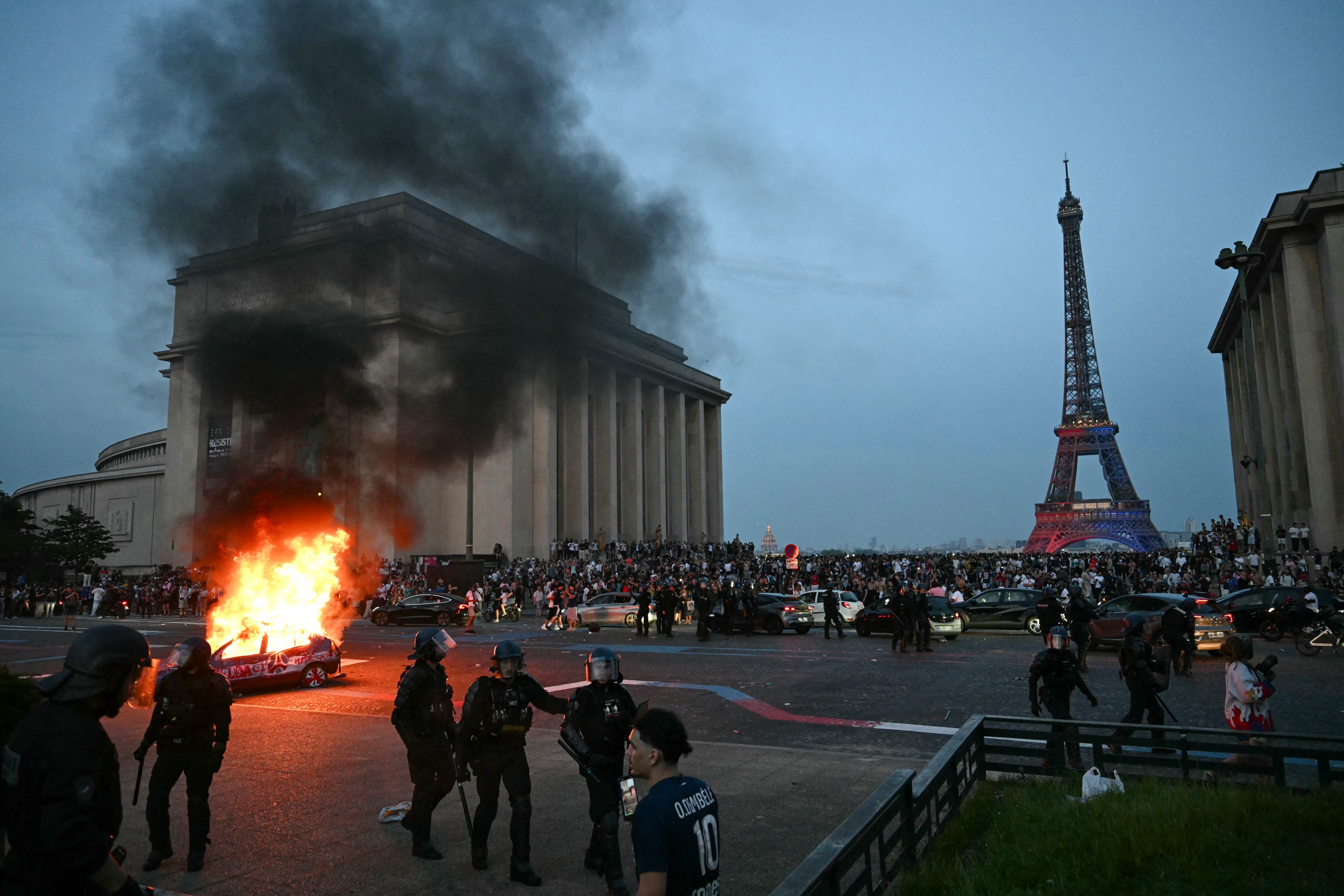 Un coche es incendiado mientras los hinchas del PSG celebran la victoria de su equipo en la final de la Liga de Campeones de la UEFA ante el Arsenal FC, disputada en Budapest. (Foto de LOU BENOIST / AFP).