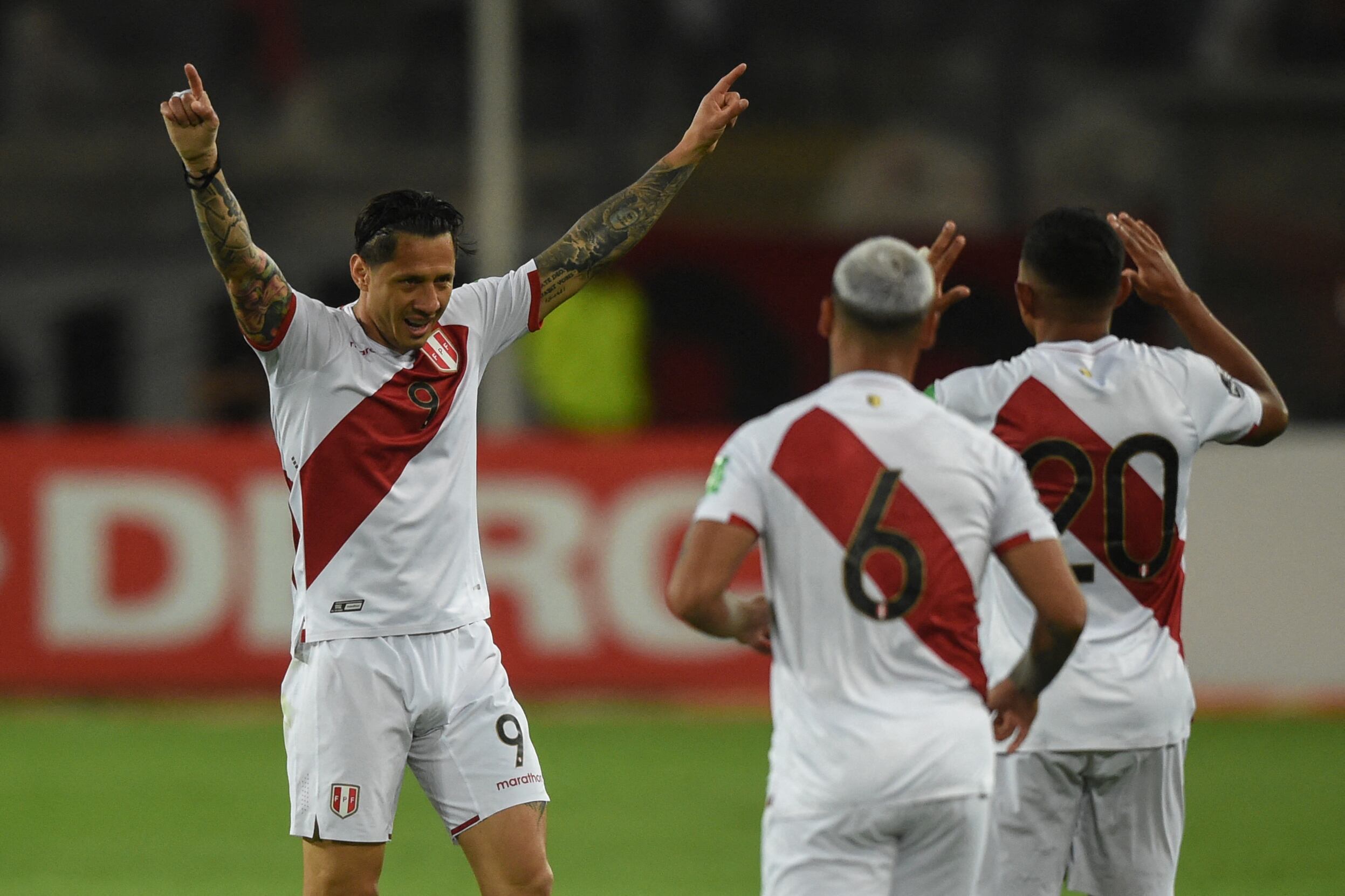 Peru's Gianluca Lapadula (L) celebrates after scoring against Paraguay during their South American qualification football match for the FIFA World Cup Qatar 2022 at the National Stadium in Lima on March 29, 2022. (Photo by ERNESTO BENAVIDES / AFP)
