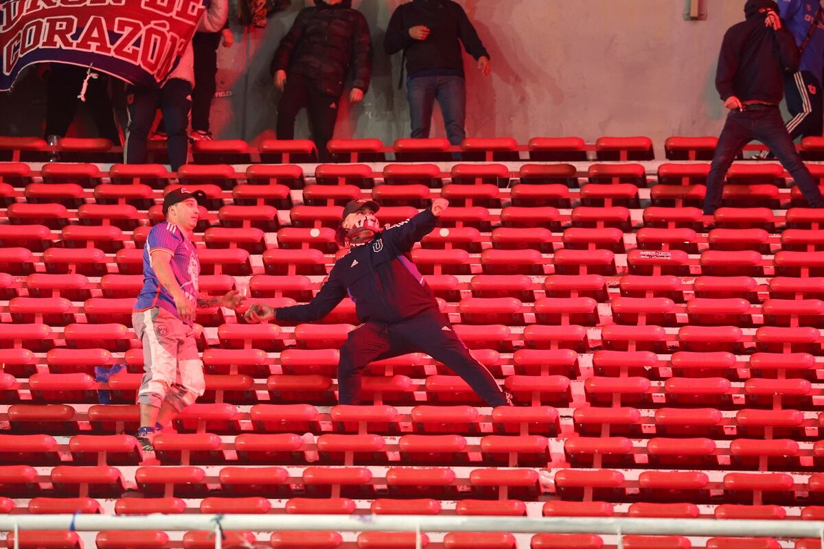 Un fanático de la Universidad de Chile se prepara para lanzar una piedra durante el partido entre Independiente y la U de Chile. (Foto de Alejandro PAGNI / AFP)