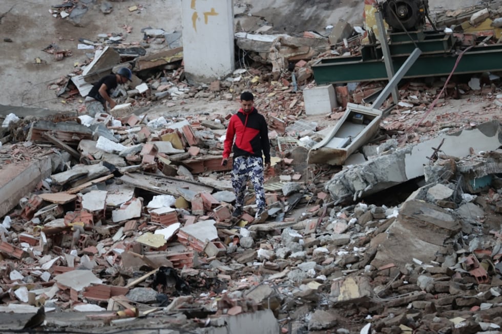 Residentes entre los escombros de uno de los bloques de viviendas dañados por los terremotos, en la localidad de Catia La Mar, en el estado costero de La Guaira (Venezuela) este jueves. EFE/ Ronald Pena R.