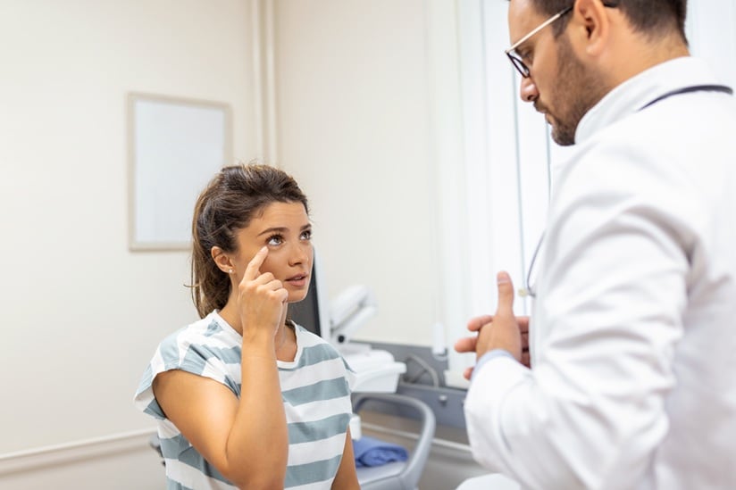 Woman having a eye problem and pain. Doctor working in the office and listening to the patient, she is explaining her symptoms, healtcare and assistance concept