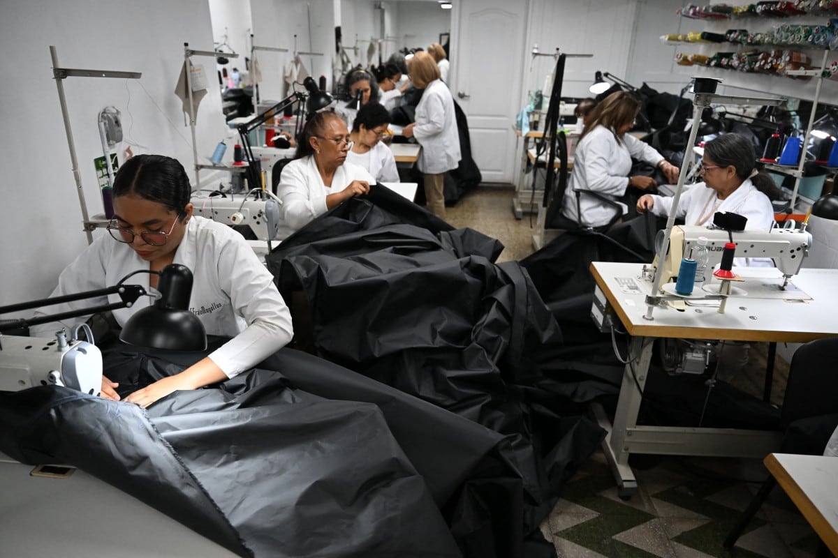 Las costureras dejaron de confeccionar vestidos para elaborar bolsas mortuorias y, posteriormente, lonas para refugios temporales, en respuesta a las necesidades surgidas tras los devastadores sismos que afectaron Caracas y el estado La Guaira. (Photo by Raul ARBOLEDA / AFP)