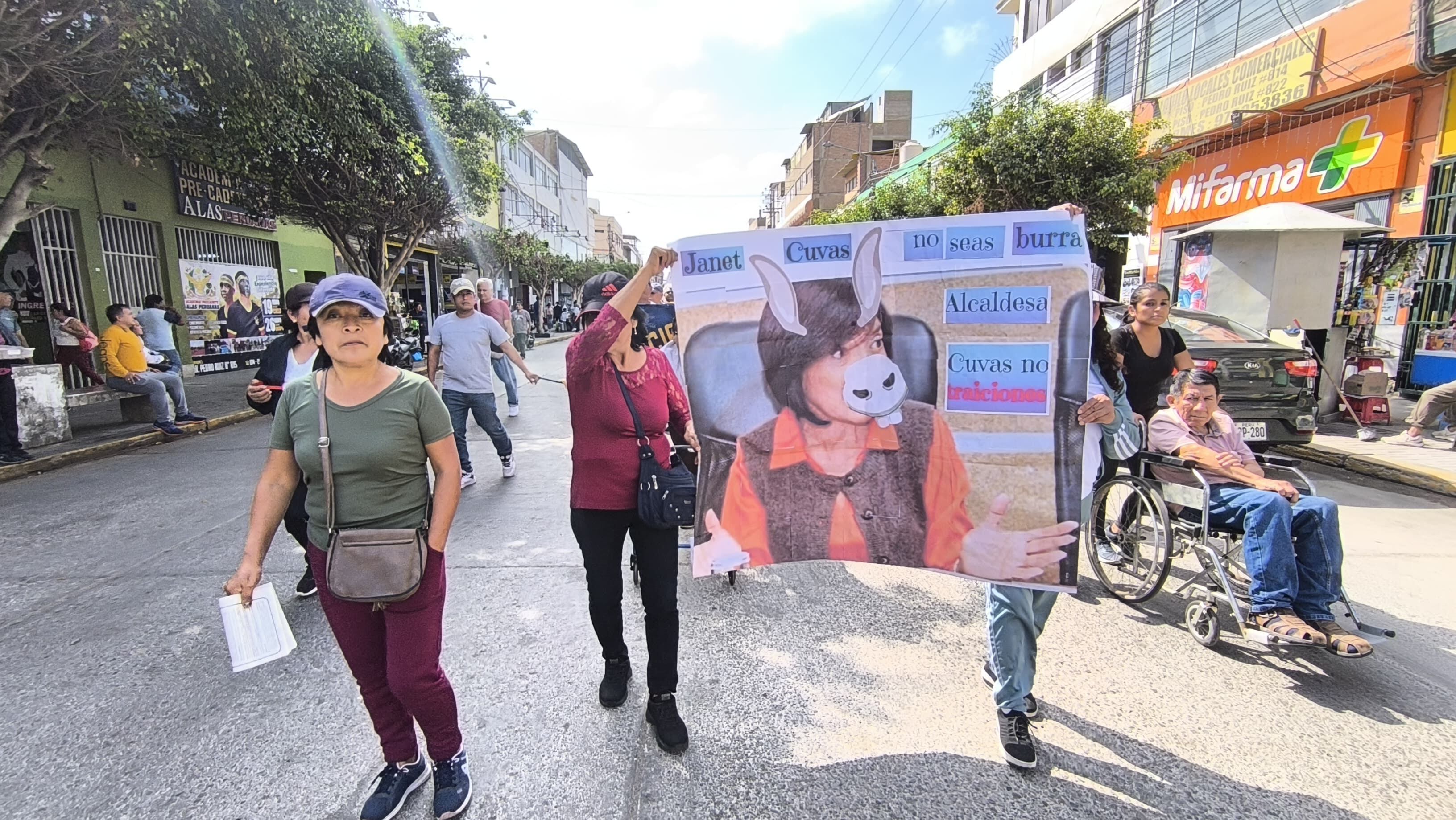 Comerciantes llevaron carteles con la imagen de la alcaldesa Janet Cubas, que fue cubierto con figuras de un burro.