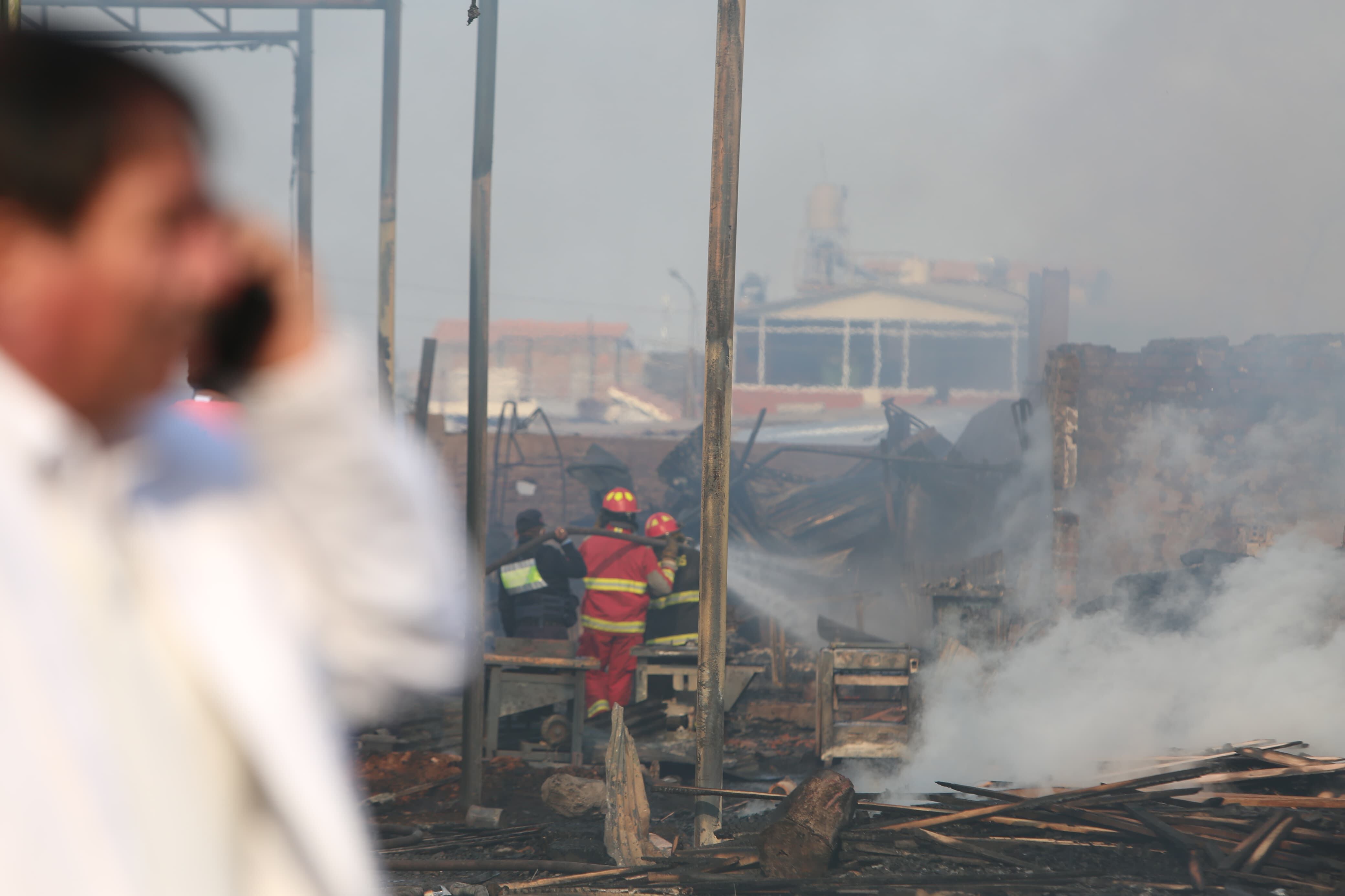 Hombres de rojo combaten las llamas. (Foto: Leonardo Cuito)
