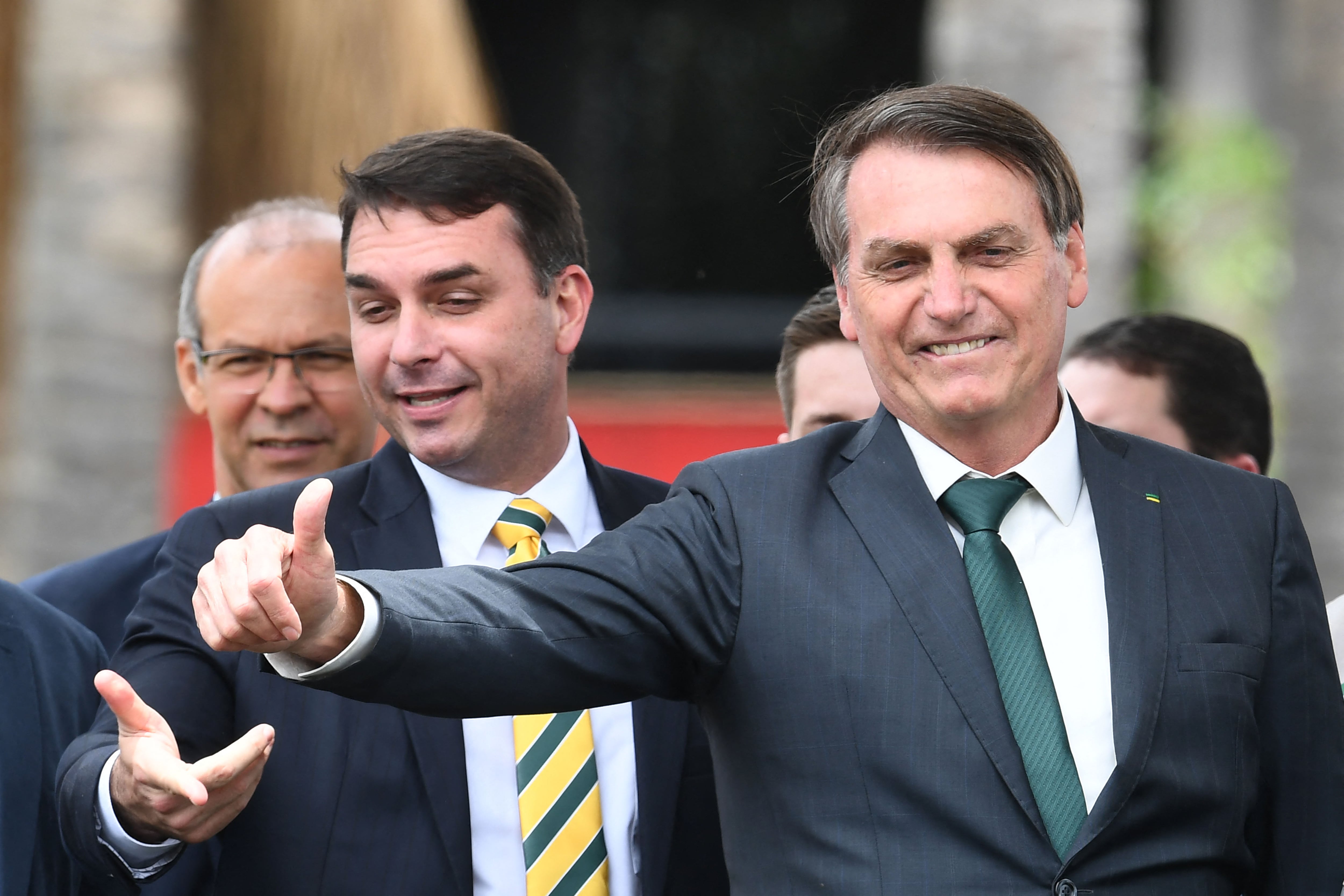 El presidente brasileño Jair Bolsonaro (derecha) y su hijo, el senador Flavio Bolsonaro. (Foto por EVARISTO SA / AFP)
