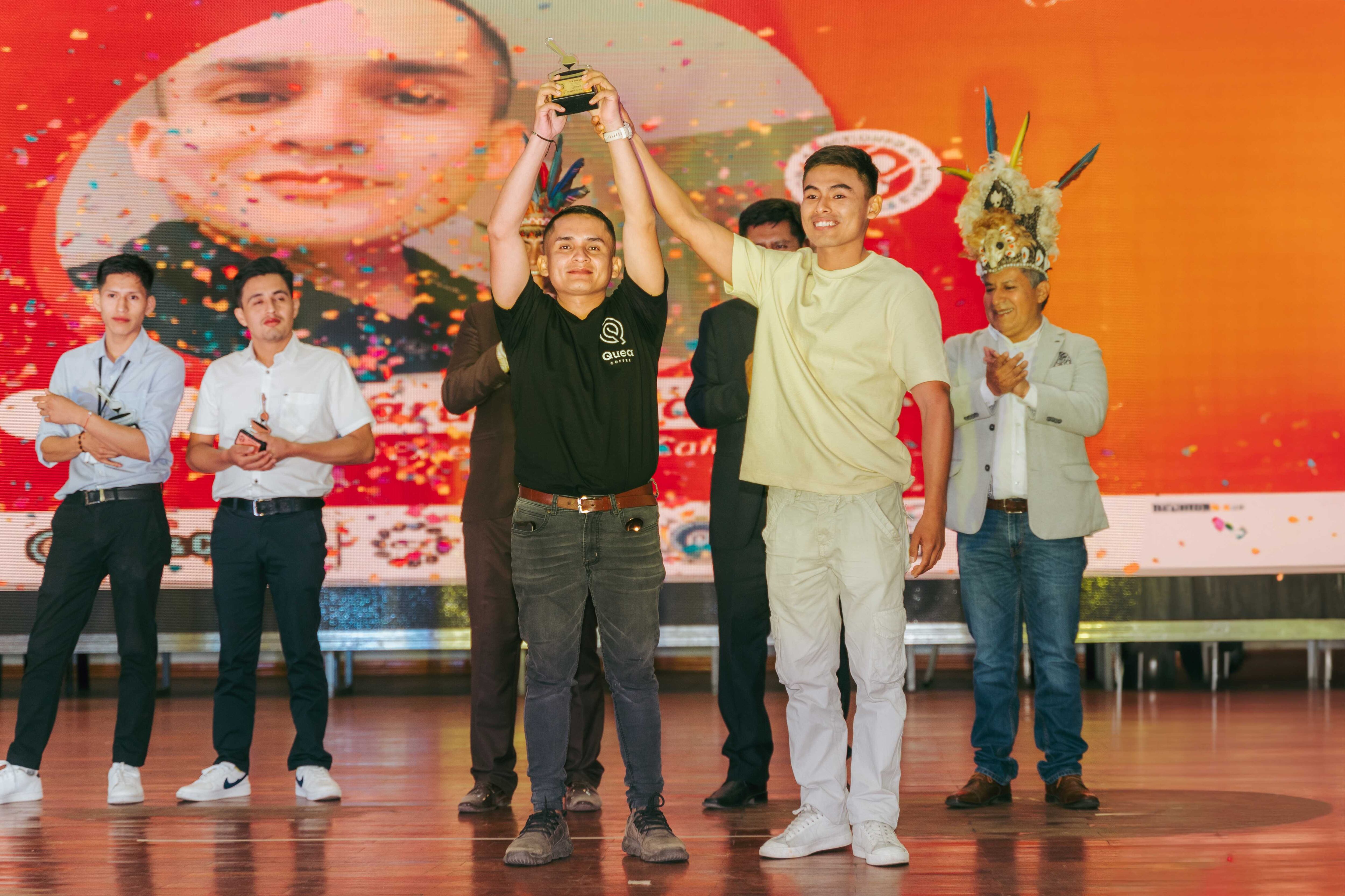 Eric Jara (izquierda) recibe el trofeo como mejor catador de manos de Junior Zanabria, campeón del año pasado.