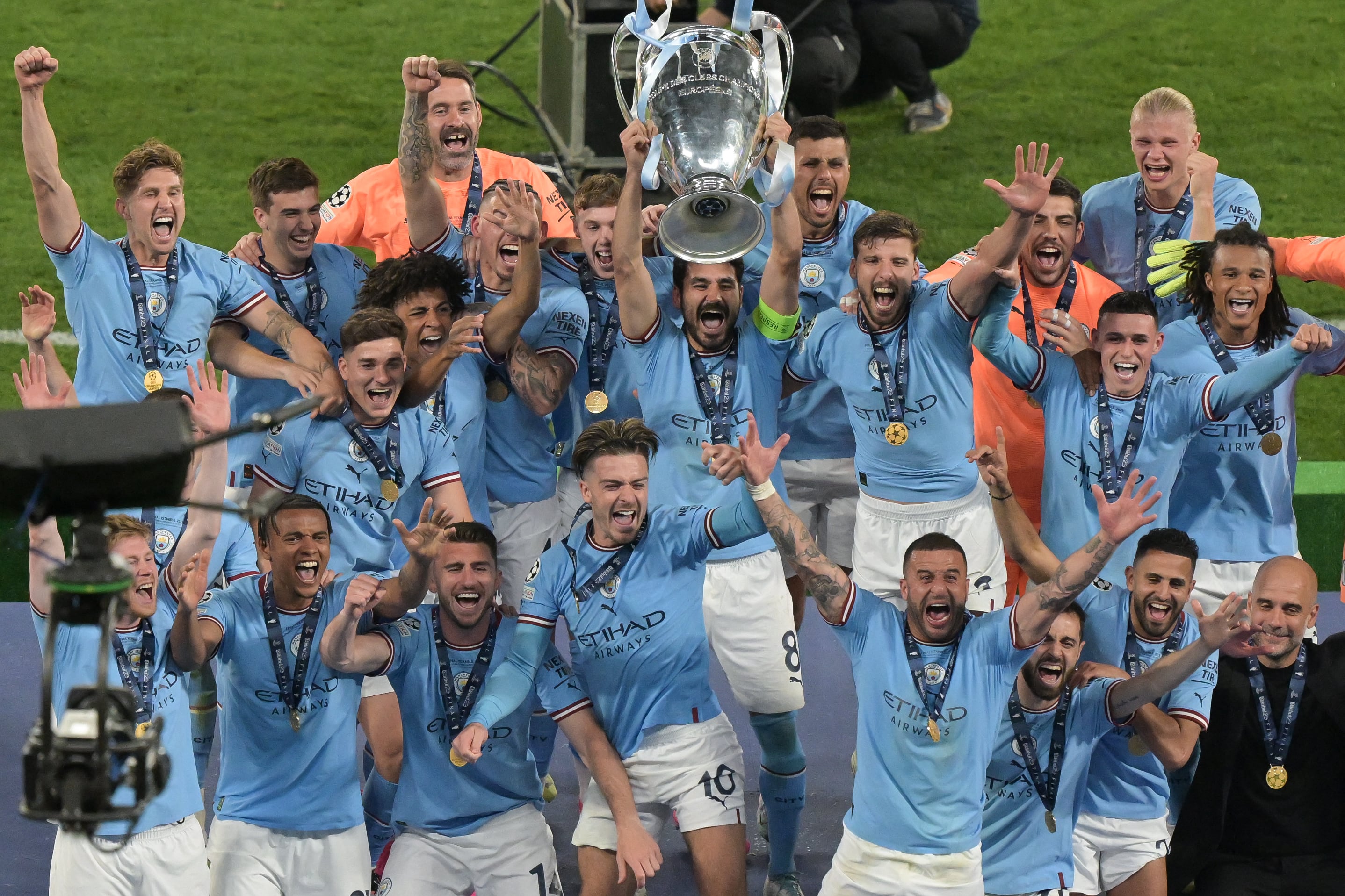 El mediocampista alemán del Manchester City #8 Ilkay Gundogan (C) levanta el trofeo de la Copa de Europa mientras celebran en el podio después de ganar el partido de fútbol final de la Liga de Campeones de la UEFA entre el Inter de Milán y el Manchester City en el Estadio Olímpico Ataturk en Estambul, el 10 de junio de 2023 (Foto de BULENT KILIC / AFP)