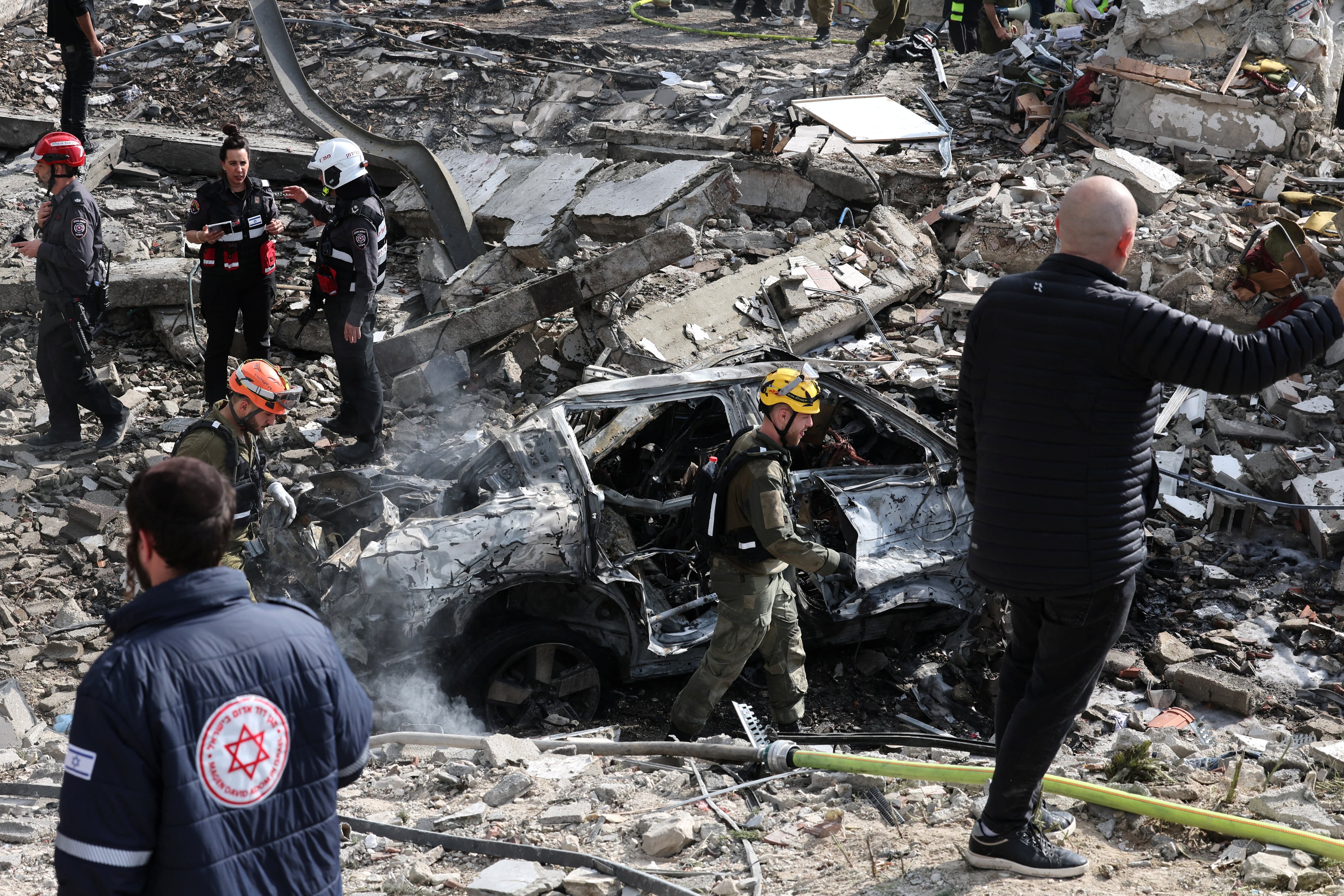 Un agente del servicio de emergencias de Israel camina junto a los escombros de un edificio en el lugar de un ataque con misiles cerca de Bet Shemesh, al oeste de Jerusalén. (Foto: Ahmad GHARABLI / AFP).
