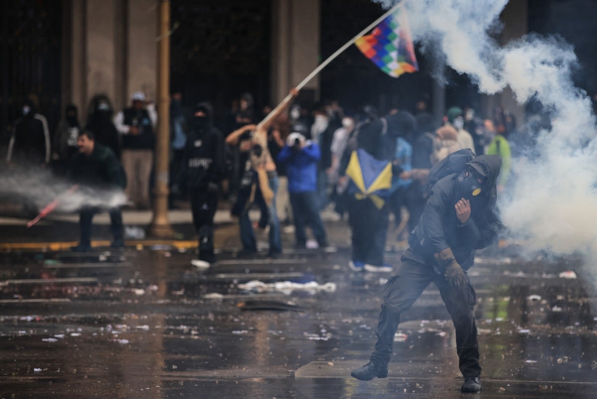 A man throws tear gas during a demonstration demanding that the government of Argentine President Javier Milei comply with a law updating funding for public universities, in Buenos Aires, on October 15, 2026. (Photo by Emiliano Lasalvia / AFP)