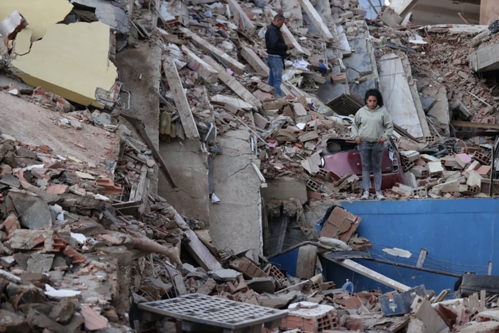 Residentes caminan entre los escombros de edificios derrumbados por los terremotos, en la localidad de Catia La Mar, en el estado costero de La Guaira (Venezuela), este jueves. EFE/ Ronald Pena R.