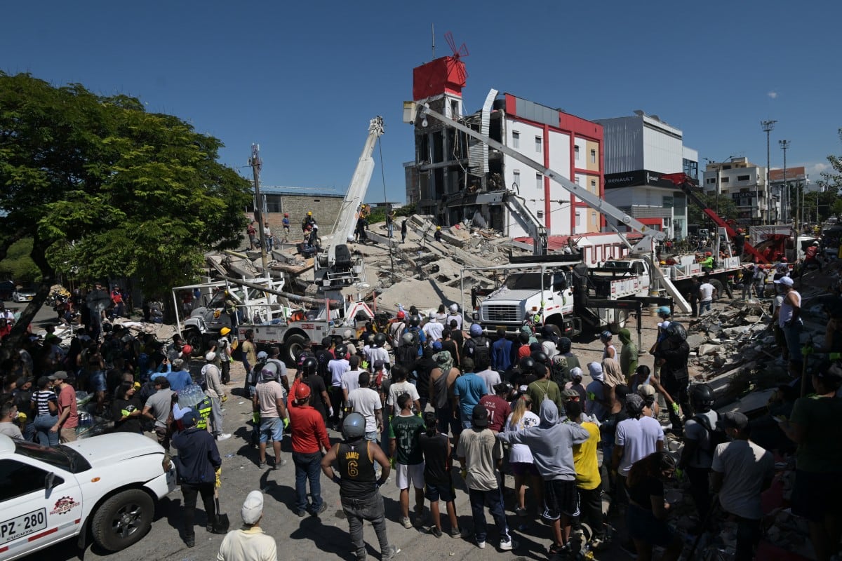 Personas buscan sobrevivientes entre los escombros de un edificio derrumbado tras un terremoto en Cali, Colombia, el 10 de agosto de 2026. (JOAQUIN SARMIENTO / AFP)
