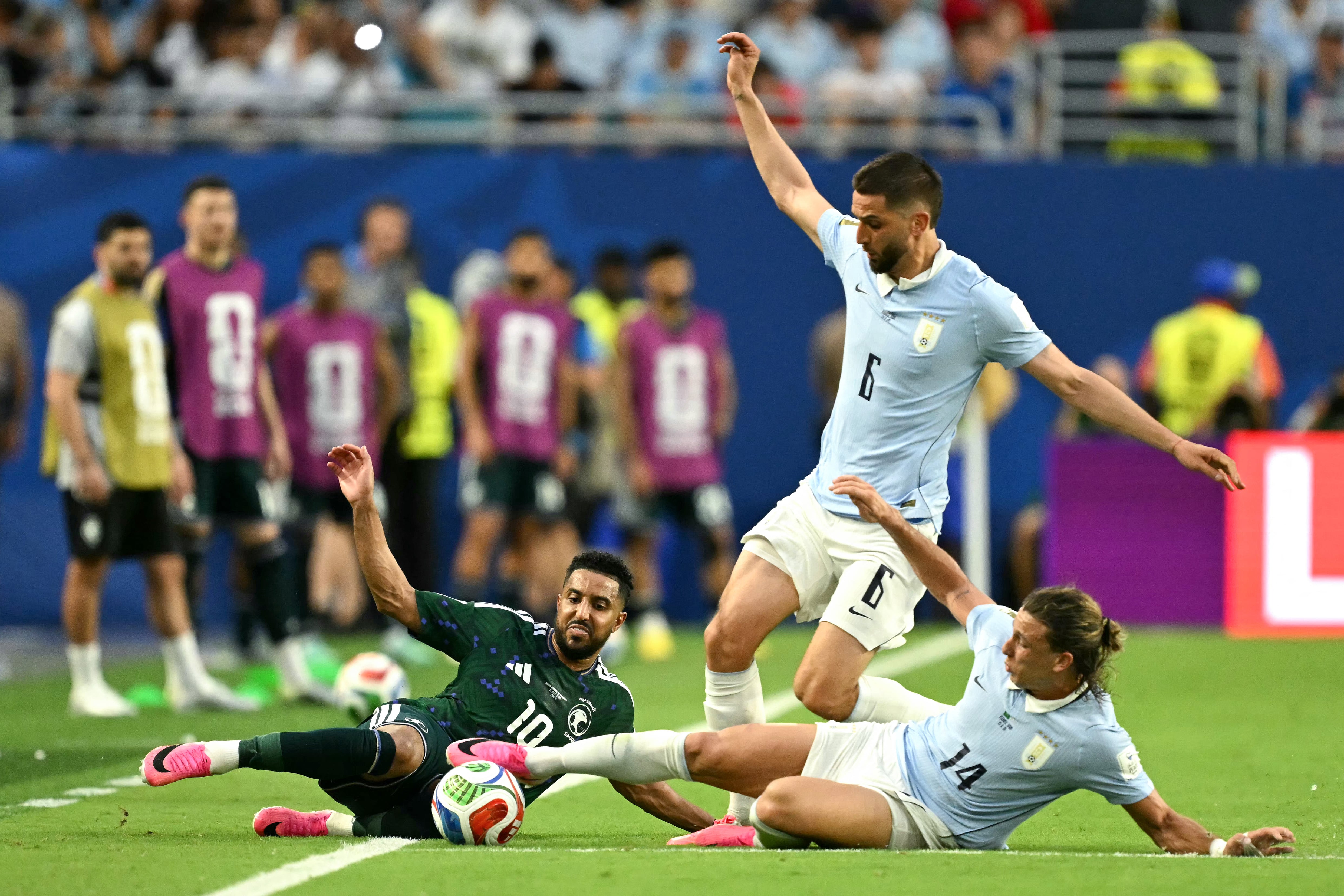 Saudi Arabia's forward #10 Salem Al-Dawsari, Uruguay's midfielder #06 Rodrigo Bentancur and forward #14 Agustin Canobbio fight for the ball during the 2026 World Cup Group H football match between Saudi Arabia and Uruguay at the Miami Stadium in Miami Gardens on June 15, 2026. (Photo by CHANDAN KHANNA / AFP)