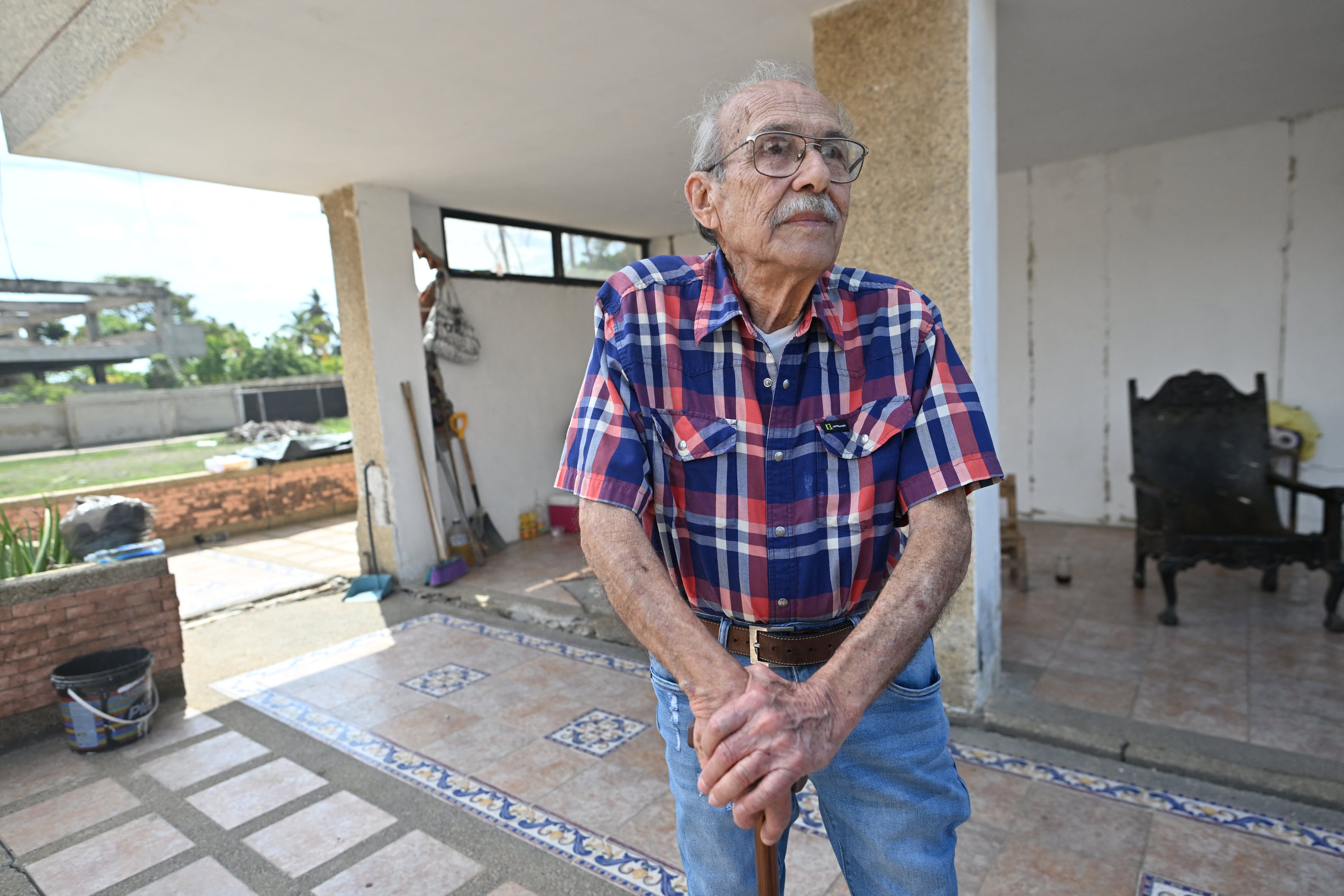 Engineer Elias Chayeb poses for a picture in Catia La Mar, La Guaira state, Venezuela, on July 6, 2026. In a block of flats reduced to ruins, a modest three-storey building still stands. The engineer who helped build it wept with joy when he saw that it had withstood the two violent earthquakes that left more than 3,500 people dead in Venezuela. (Photo by Juan BARRETO / AFP)