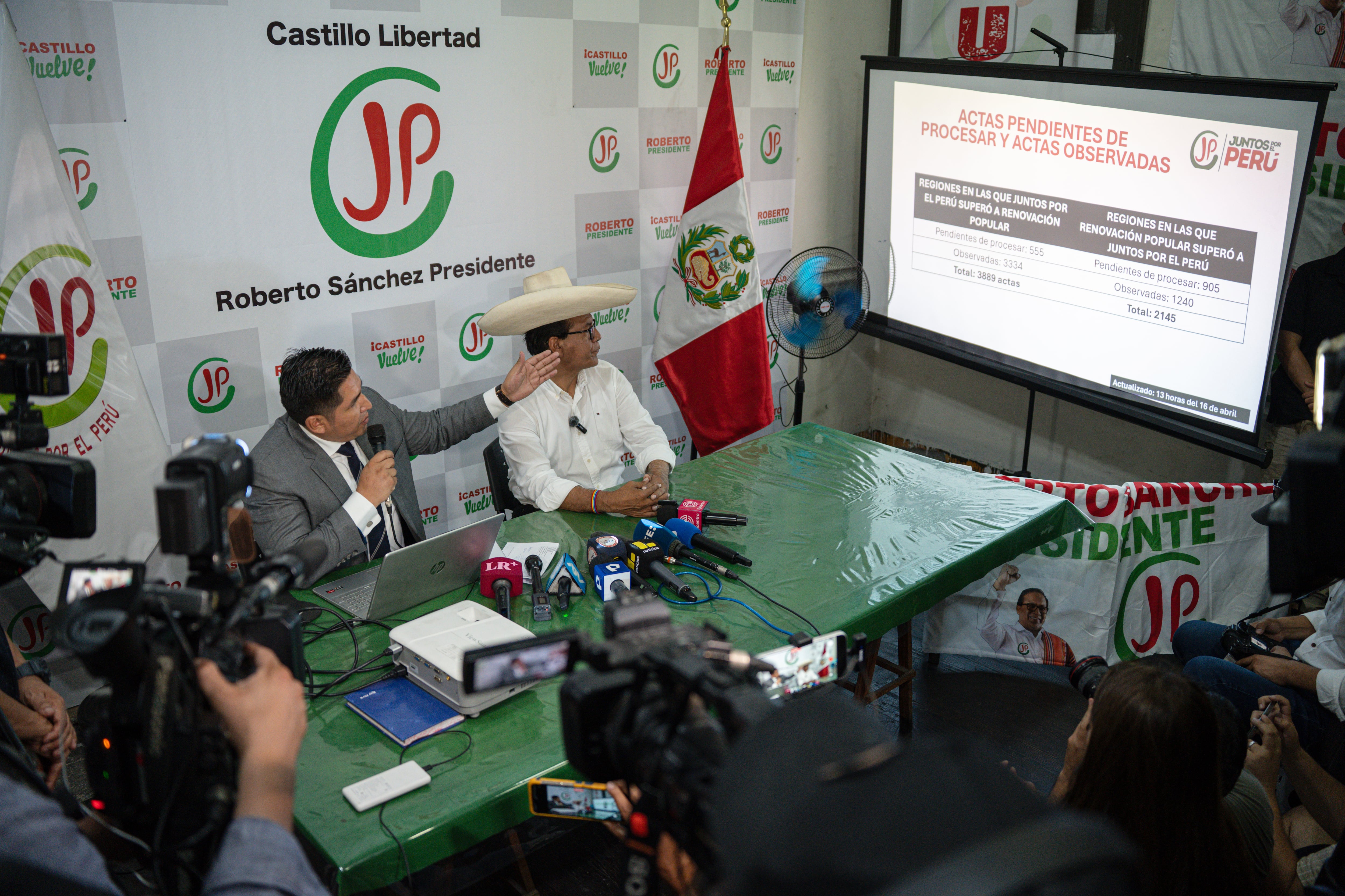 AME4196. LIMA (PERÚ), 16/04/2026.- El candidato a la Presidencia de Perú por el partido Juntos por el Perú, Roberto Sánchez (d), observa una pantalla junto su nuevo vocero, el abogado Rey Mendoza, en una rueda de prensa este jueves, en Lima (Perú). Sánchez dijo que estarán pendientes de alguna manipulación por parte de López Aliaga o Keiko Fujimori. EFE/ John Reyes Mejía