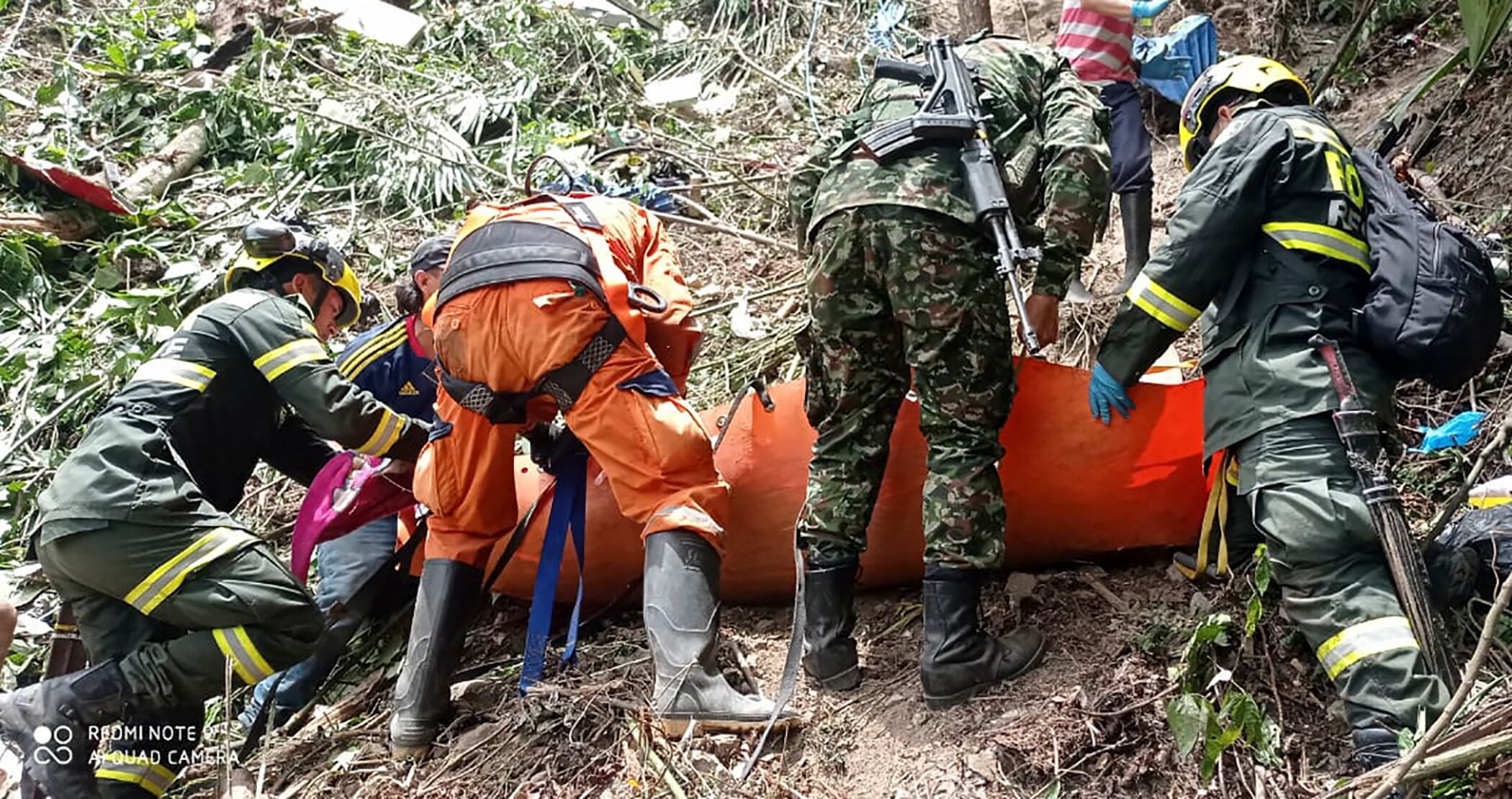 Miembros de la Policía y de la Defensa Civil brindando asistencia a una víctima después de que un autobús cayera en un barranco en la carretera Cúcuta-Bucaramanga, en Colombia, el 22 de julio de 2023. (Foto por Ejército de Colombia / AFP)