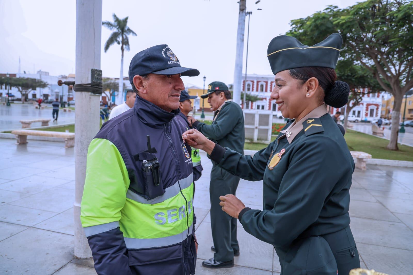 Efectivos policiales colocaron la escarapela a los funcionarios municipales y a personas presentes en la plaza mayor, incluyendo a trabajadores del Servicio de Gestión Ambiental que realizaban labores de limpieza y de mejoramiento de las áreas verdes.