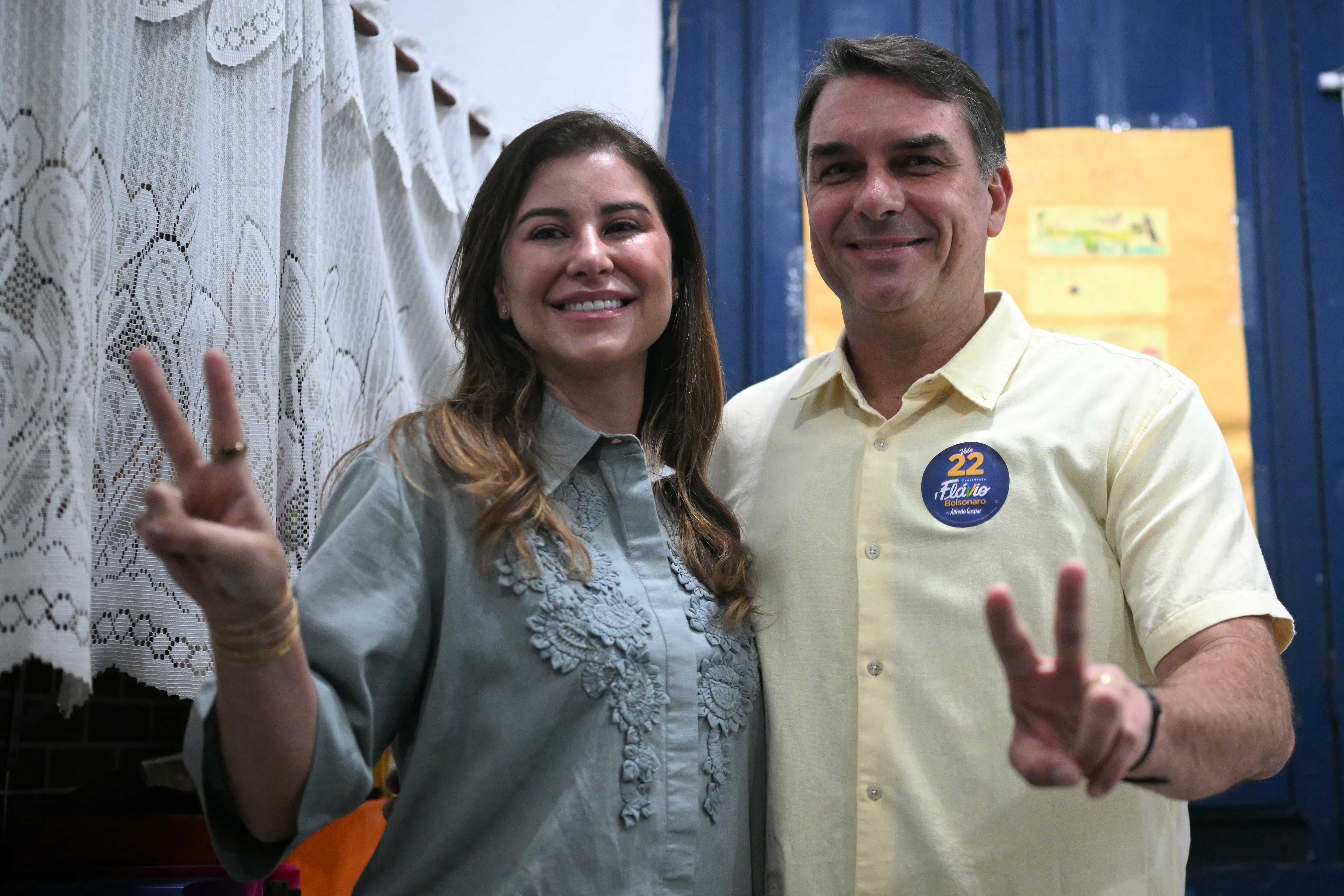 Flavio Bolsonaro, y su esposa, Fernanda Bolsonaro, hacen el signo de la victoria durante la segunda vuelta de las elecciones presidenciales en un colegio electoral de Río de Janeiro, Brasil, el 25 de octubre de 2026. (Foto de MAURO PIMENTEL / AFP).