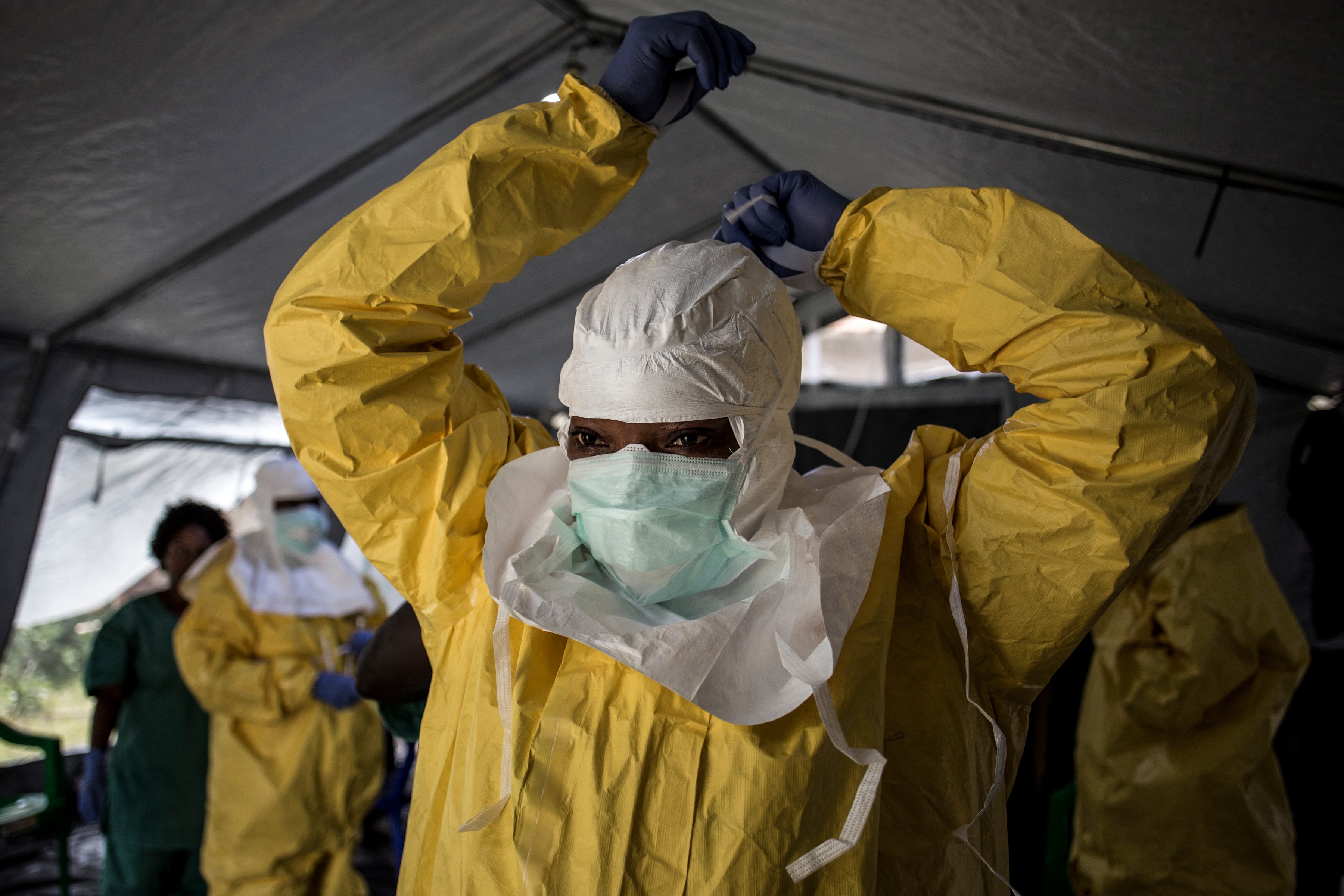 Una trabajadora sanitaria se coloca su equipo de protección personal (EPP) antes de entrar en un centro de tratamiento del ébola en Beni el 12 de agosto del 2018. (John WESSELS / AFP / Archivo).