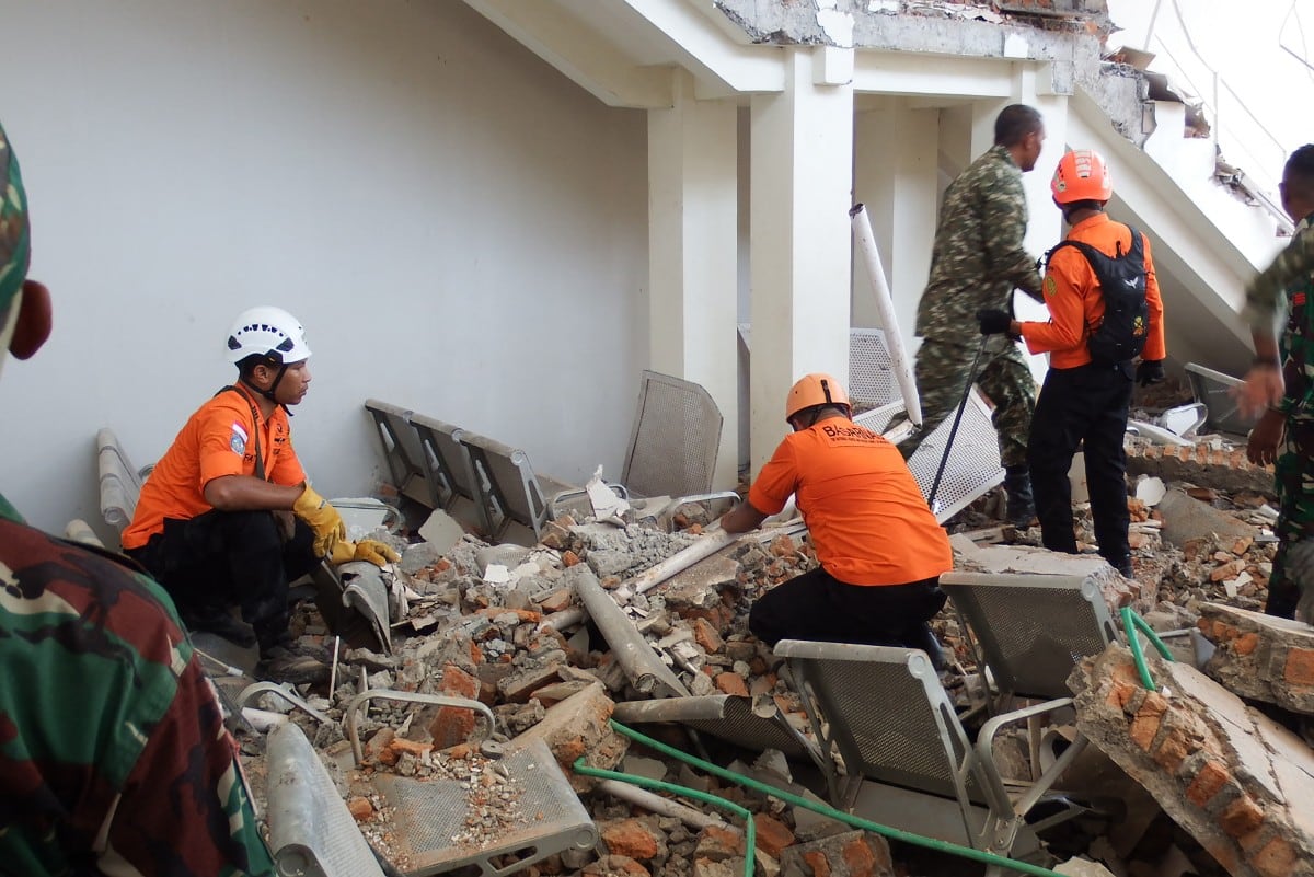 Un equipo de rescate busca víctimas entre las ruinas del puerto de Laurensius Say en Maumere, Sikka, Nusa Tenggara Oriental, el 15 de agosto de 2026, después de que un terremoto de magnitud 7,7 sacudiera la isla de Flores. (ARNOLD WELIANTO / AFP)