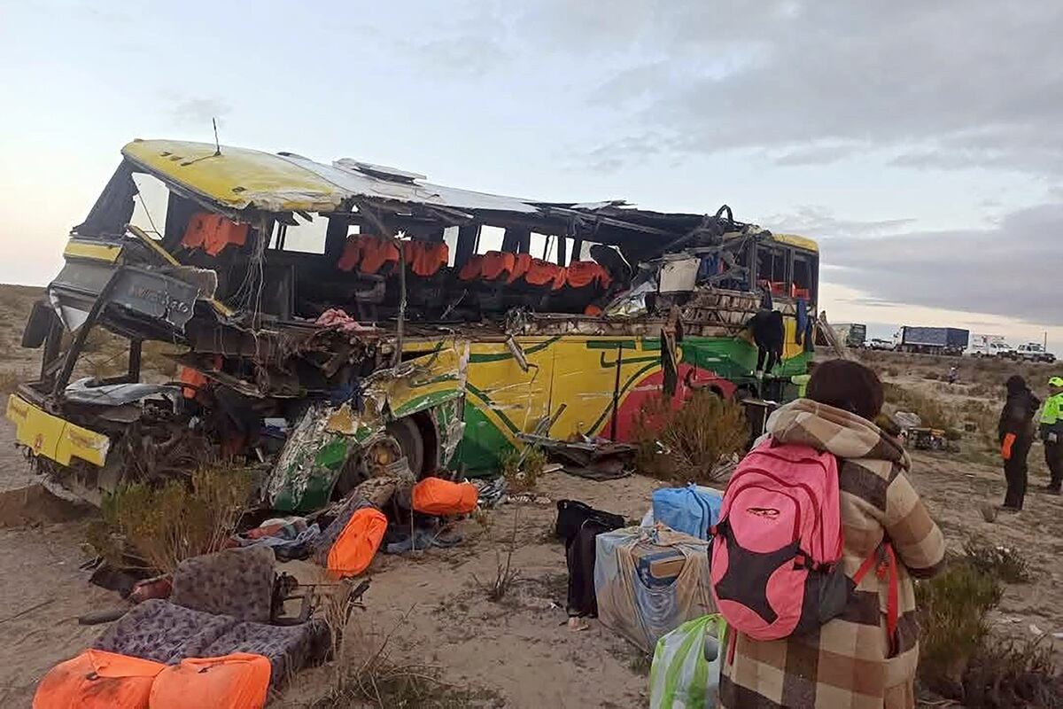 Una mujer camina cerca de los restos de un autobús que chocó con otro en una carretera cerca de Uyuni, Bolivia. (Foto: Policía boliviana / AFP)
