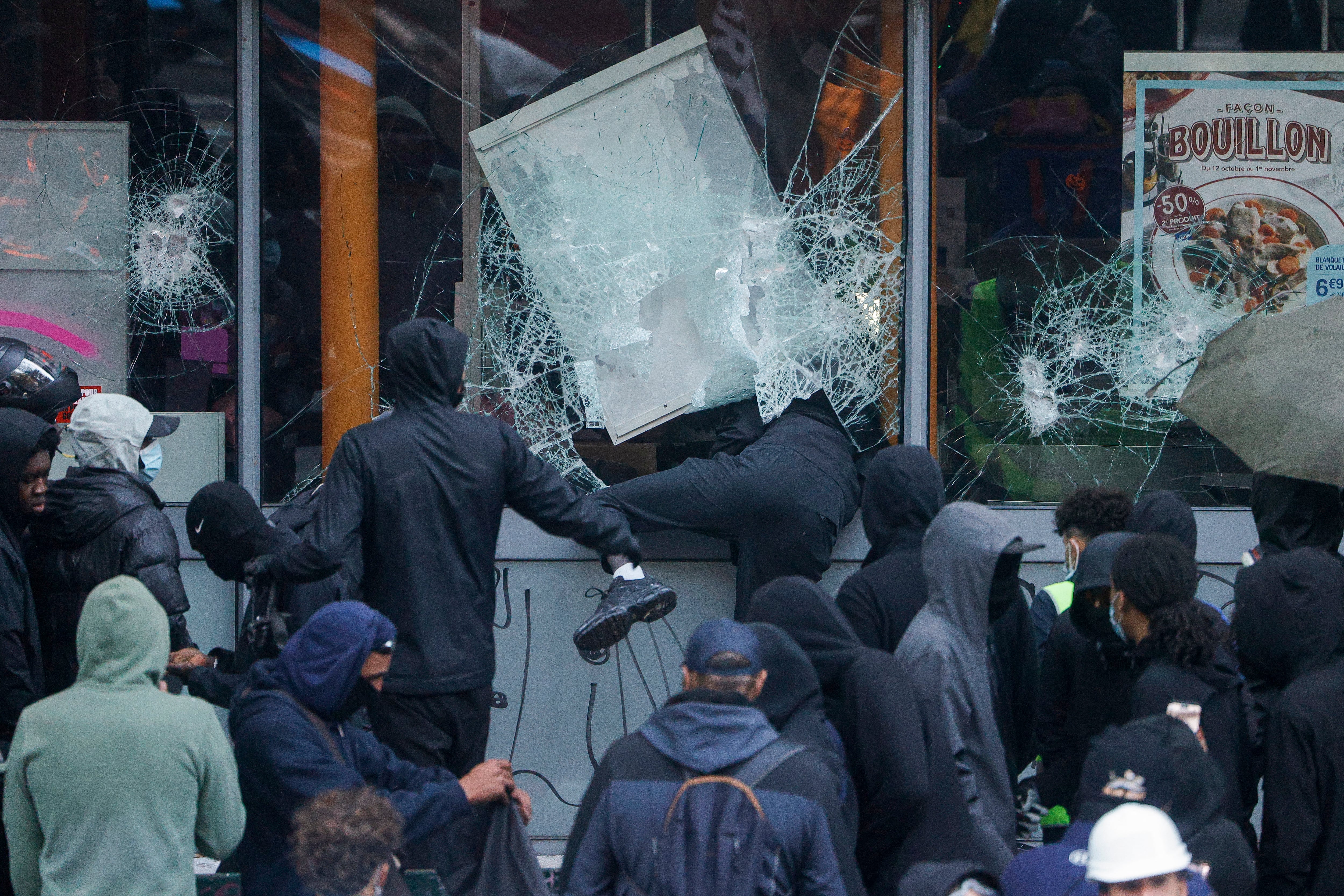 Manifestantes rompen los escaparates de una tienda durante una protesta contra el elevado coste de la vida en París, Francia. (Foto de GEOFFROY VAN DER HASSELT / AFP).