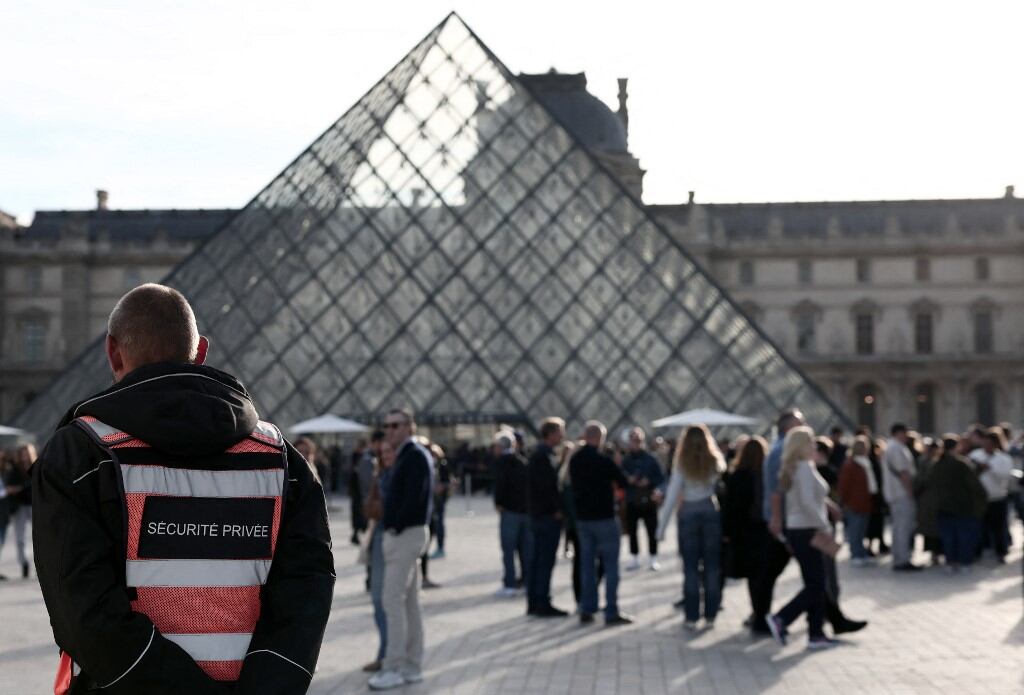 Un guardia de seguridad custodia la Pirámide del Louvre, tras robo de joyas ocho joyas. (Foto: AFP)