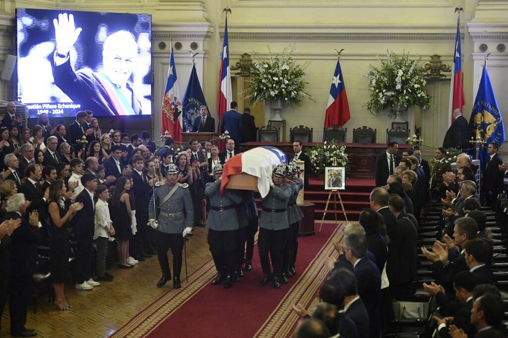 La esposa del fallecido expresidente Sebastián Piñera, Cecilia Morel, acompañada de su familia, camina mientras carabineros transportan el ataúd de Piñera durante su funeral de estado en el Palacio del Congreso Nacional en Santiago el 9 de febrero de 2024. Expresidentes y políticos de Chile , de izquierda a derecha, así como familiares y seguidores despiden este viernes al expresidente Sebastián Piñera, quien falleció el martes mientras piloteaba su helicóptero en el sur del país. (Foto de Pablo Vera/AFP)
