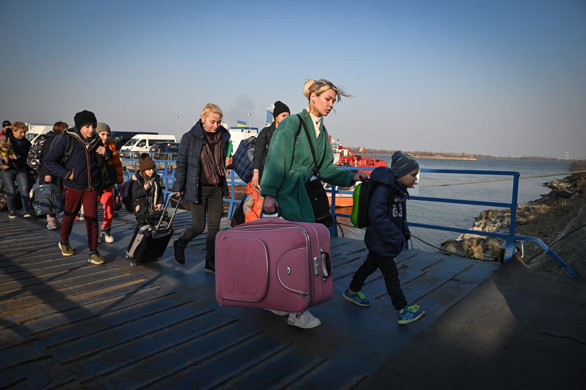 Refugiados de Ucrania caminan por el embarcadero después de llegar en ferry al punto fronterizo rumano-ucraniano Isaccea-Orlivka el 24 de marzo de 2022. (Foto: Daniel MIHAILESCU / AFP)