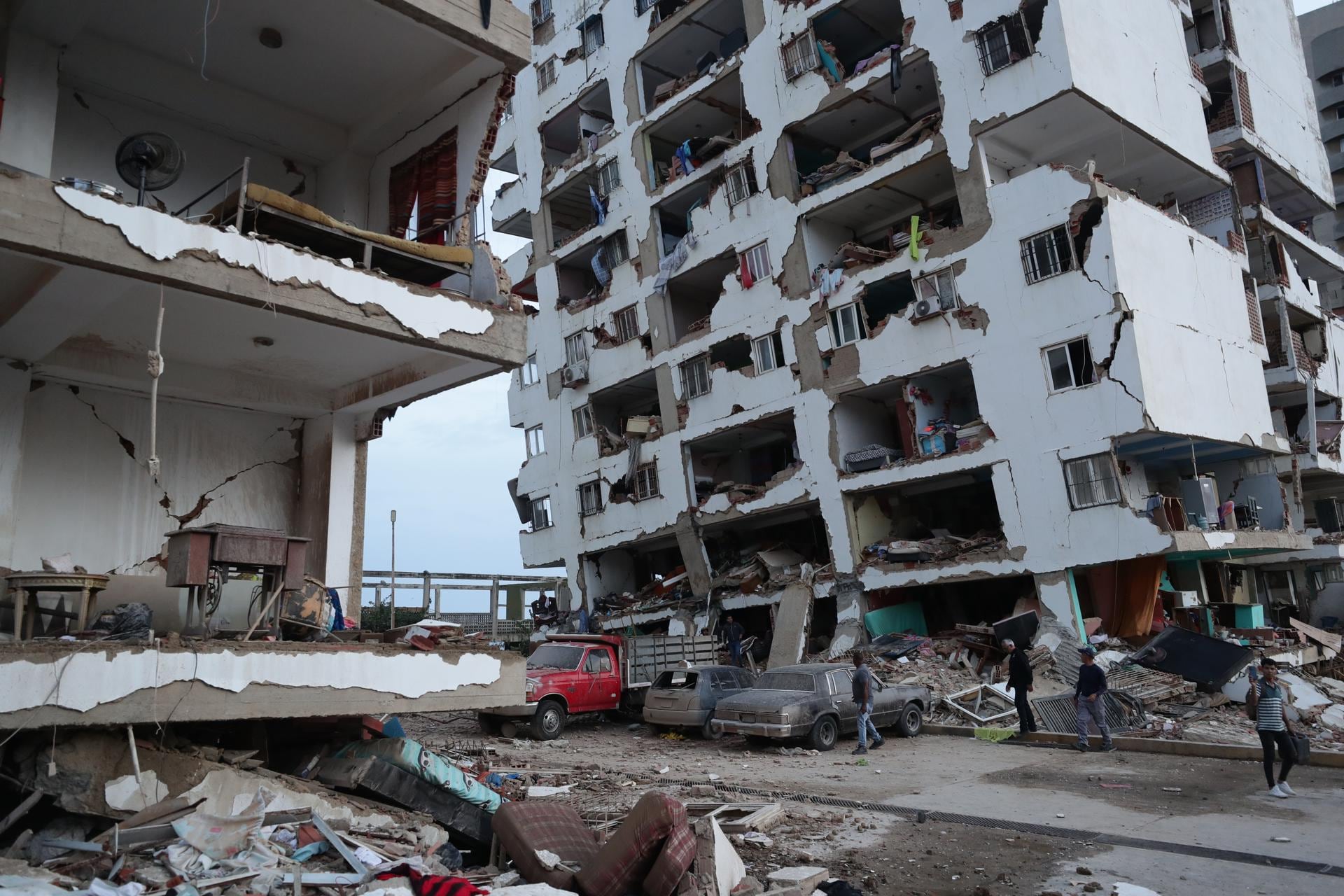 Residentes caminan entre los escombros de varios bloques de viviendas dañados por los terremotos en la localidad de Catia La Mar, en el estado costero de La Guaira, Venezuela. (EFE/ Ronald Pena R.).