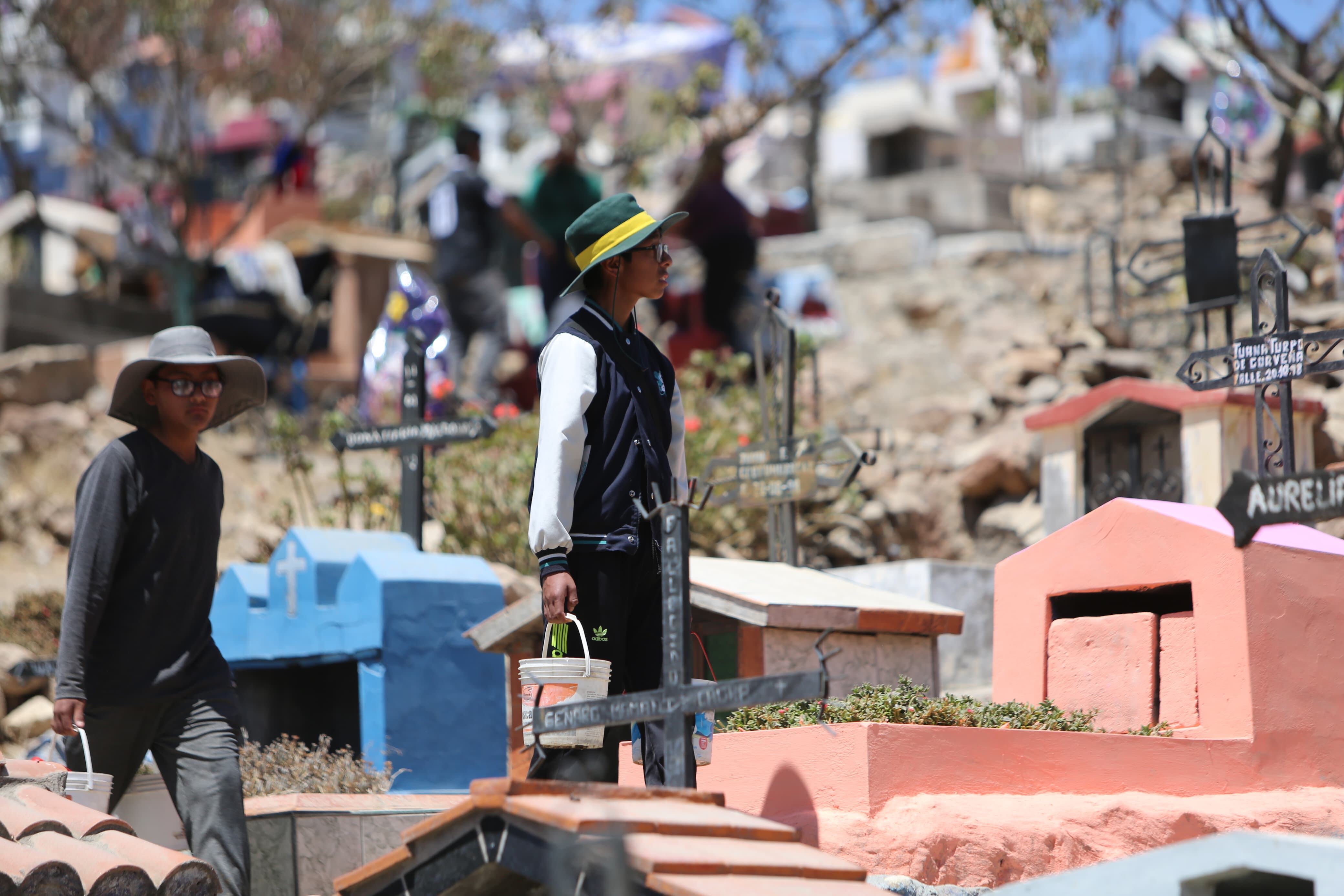 Niños ofrecen agua para limpiar tumbas. (Foto: Leonardo Cuito)