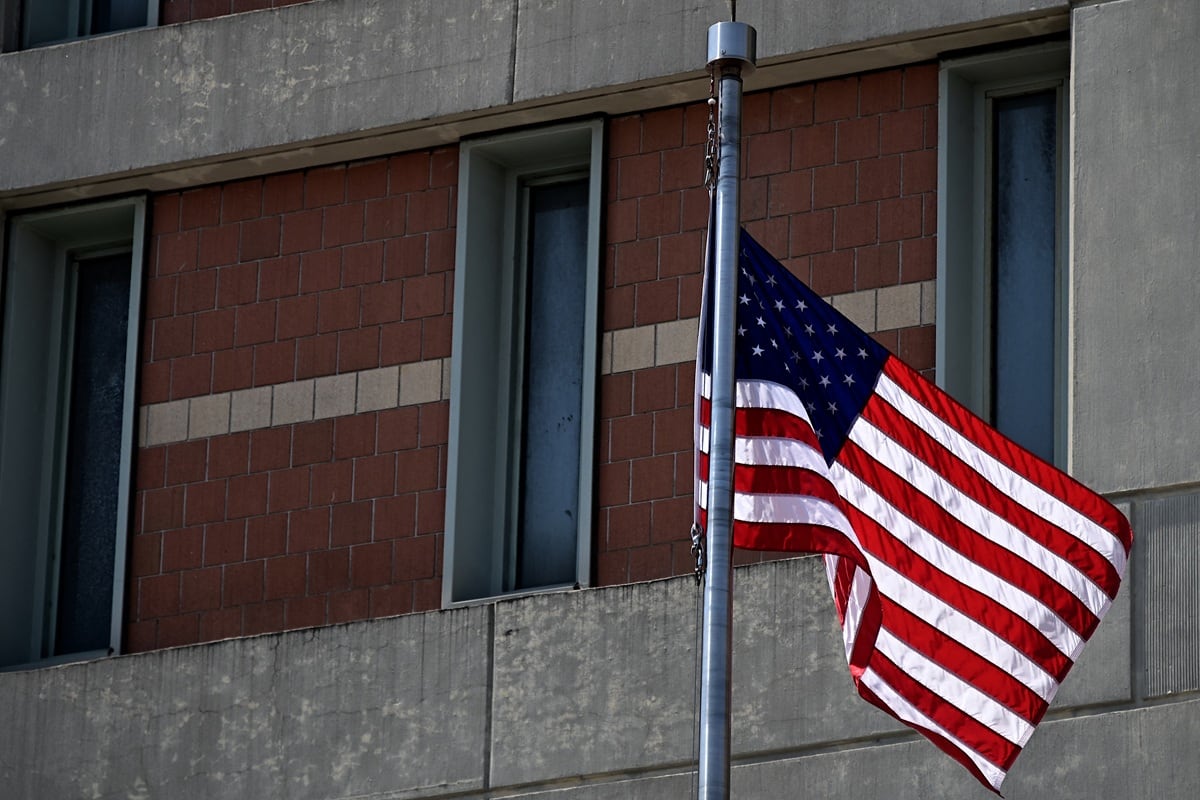 Una bandera estadounidense se ve frente al Centro de Detención Metropolitano (MDC) en Brooklyn, un centro de detención administrativa federal de los Estados Unidos, el 6 de julio de 2020 en la ciudad de Nueva York. (Johannes EISELE / AFP)