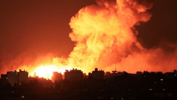 Las explosiones iluminan el cielo durante los ataques israelíes a la ciudad de Gaza el 10 de octubre de 2023. Israel dijo que recuperó las áreas fronterizas de Gaza de manos de Hamás cuando el número de muertos en la guerra superó los 3.000 el 10 de octubre, el cuarto día de agotadores combates desde que los islamistas lanzaron un ataque sorpresa. (Foto de MAHMUD HAMS / AFP)