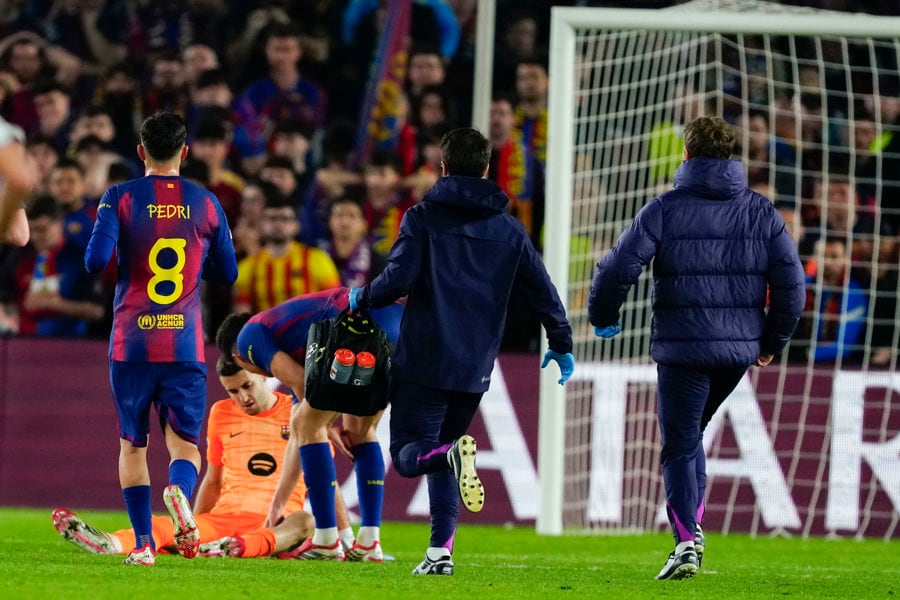 El portero del Barcelona Joan García (2i) recibe atención médica durante el partido de vuelta de los octavos de final de la Liga de Campeones. EFE/Alejandro García