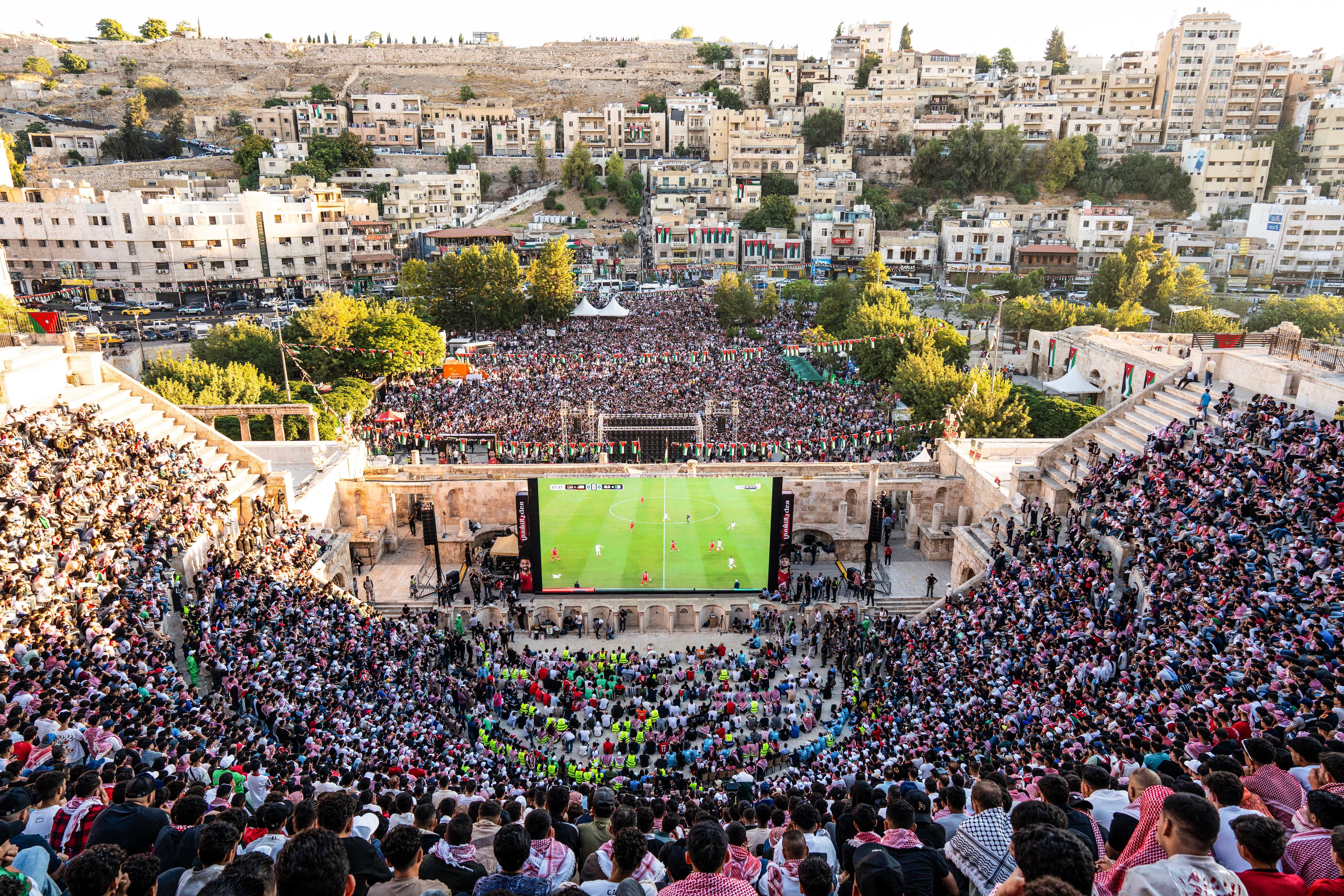 Jordanian football fans gather to watch on giant screens their national team's 2026 World Cup Group J football match against Algeria at Amman's 2nd-century Roman amphitheatre early on June 23, 2026. (Photo by George SAIF / AFP)