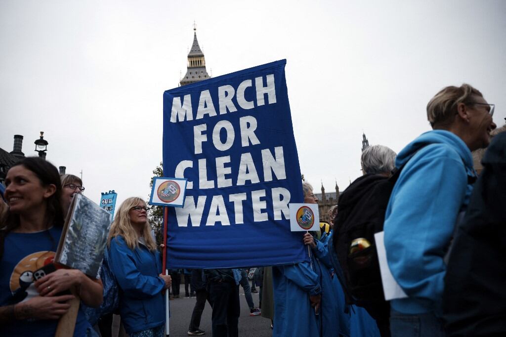 People hold placards and display banners as they take part in a "March for Clean Water" in London on November 3, 2024. (Photo by BENJAMIN CREMEL / AFP)