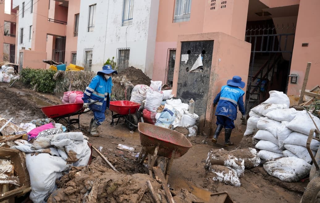 Trabajadores ayudan a extraer la arena que se almacenó en las viviendas (Foto: MPA)