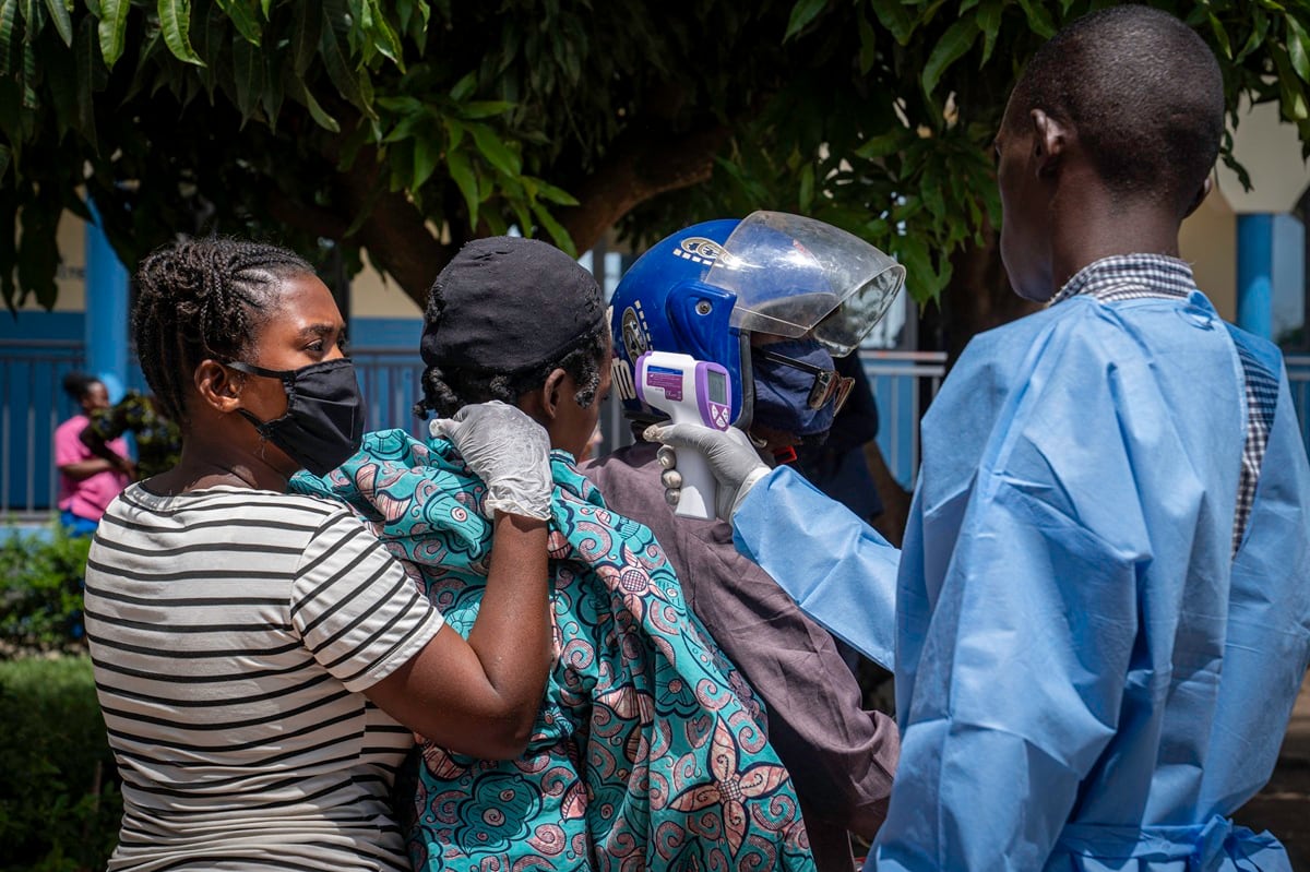 Un trabajador sanitario toma la temperatura de una paciente con sospecha de ébola mientras es trasladada en mototaxi al hospital de Rwampara en Ituri, en el este de la República Democrática del Congo, el 26 de mayo de 2026. (Glody MURHABAZI / AFP)