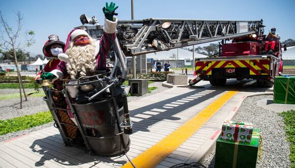En escalera de bomberos Papá Noel entrega regalos a niños con COVID-19 en Perú