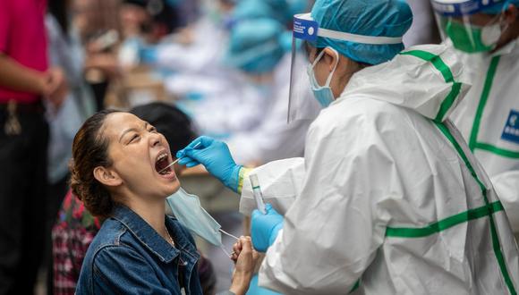 Un trabajador médico toma una muestra de hisopo de un residente en una calle de Wuhan en la provincia central de Hubei en China el 15 de mayo de 2020. (STR / AFP).