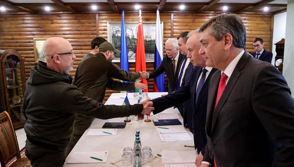 El ministro de Defensa de Ucrania, Oleksii Reznikov (izq.), estrecha la mano de los negociadores rusos antes de las conversaciones entre las delegaciones de Ucrania y Rusia en la región de Brest, en Bielorrusia, el 3 de marzo de 2022. (MAXIM GUCHEK / BELTA / AFP).
