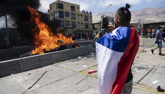 La manifestación, en la que se escucharon gritos xenófobos y se vieron muchas banderas chilenas, ocurrió luego de que la Policía desalojara una plaza donde acampaban familias con niños también en Iquique. (Foto: MARTIN BERNETTI / AFP)
