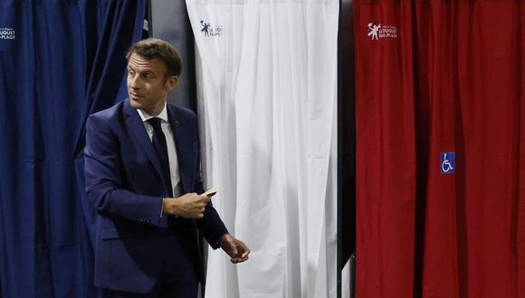 El presidente de Francia, Emmanuel Macron, ingresa a la cabina de votación para emitir su voto en las elecciones parlamentarias francesas en un colegio electoral en Le Touquet, norte de Francia, el 12 de junio de 2022. (Foto de Ludovic MARIN / POOL / AFP)