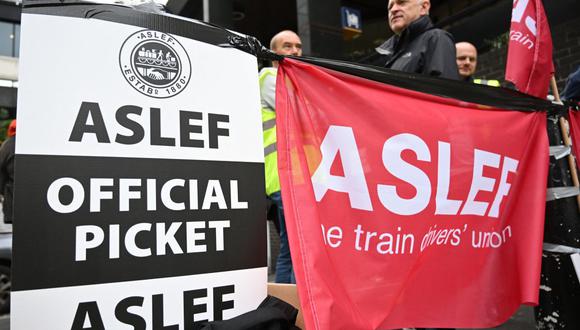 Los miembros del sindicato ASLEF (Sociedad Asociada de Ingenieros de Locomotoras y Bomberos) se reúnen en un piquete frente a la estación de Euston en Londres el 5 de octubre de 2022. (Foto de JUSTIN TALLIS / AFP)