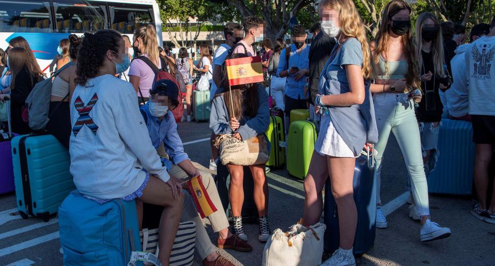 Varios estudiantes, que se encontraban en cuarentena por el macrobrote de COVID-19, aguardan a su llegada a la estación marítima para embarcar en el "barco burbuja" hacia Valencia, este jueves, en Palma de Mallorca. (EFE/Cati Cladera).
