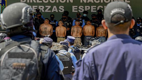 Integrantes de la banda delictiva Mara Salvatrucha (MS-13) son escoltados por agentes de la Policía Nacional en Tegucigalpa el 19 de febrero de 2021. (Foto: Orlando SIERRA / AFP)