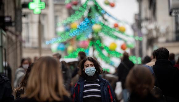 Un peatón con mascarilla camina por una calle en Nantes, en el oeste de Francia, el 31 de diciembre de 2021. (Foto de LOIC VENANCE / AFP)