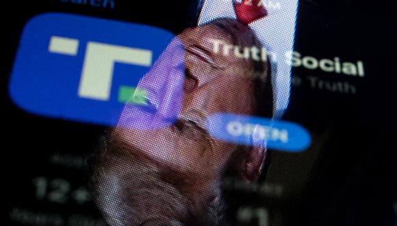 Esta ilustración fotográfica muestra una imagen del expresidente Donald Trump reflejada en la pantalla de un teléfono que muestra la aplicación Truth Social, en Washington, DC. (Foto: Stefani Reynolds / AFP)