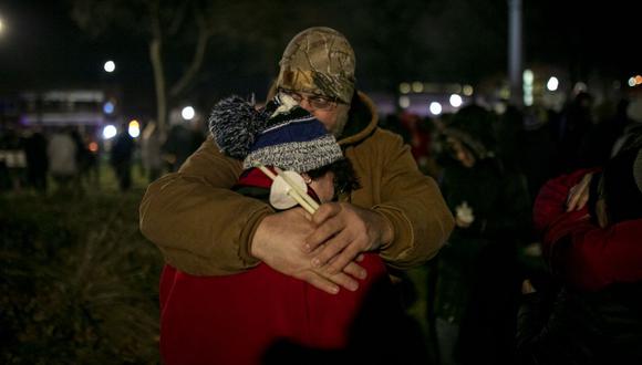 La gente se abraza durante una vigilia en Cutler Park en Waukesha, Wisconsin. Seis personas murieron y varias resultaron heridas después de que Darrell Brooks, Jr. condujera un SUV por la ruta de un desfile navideño el 21 de noviembre. (Foto de Jim Vondruska / GETTY IMAGES NORTH AMERICA / AFP)