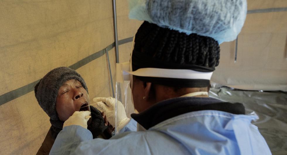 Una residente de Sophia Town, Johannesburgo, abre la boca para recibir un hisopo de prueba para el coronavirus COVID-19 en el patio de la Clínica Sophia Town, el 28 de abril de 2020. (Luca Sola / AFP).